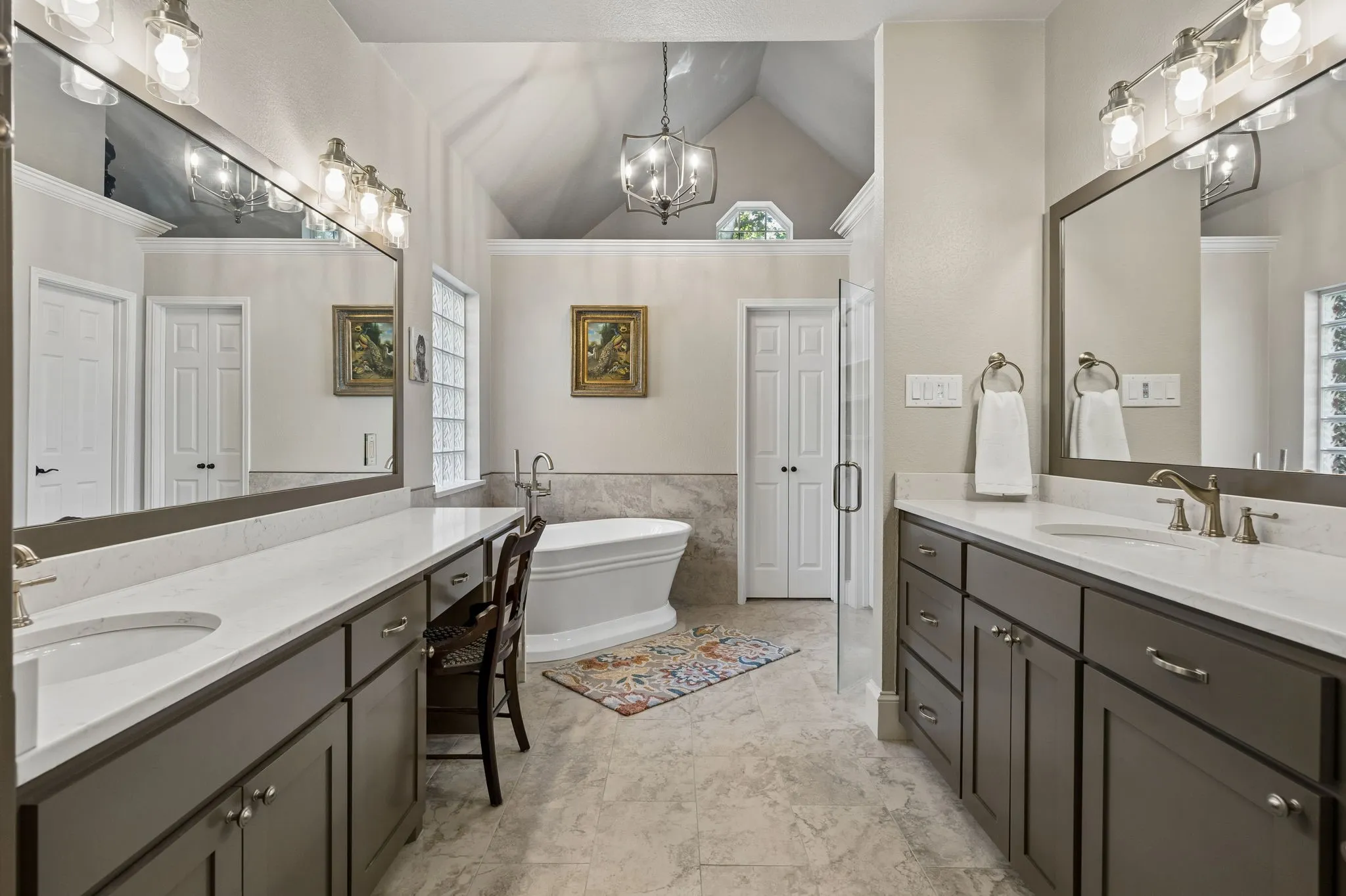 Primary Bathroom dual vanity with integrated cabinetry, polished chrome fixtures, white countertop, and a built-in makeup vanity