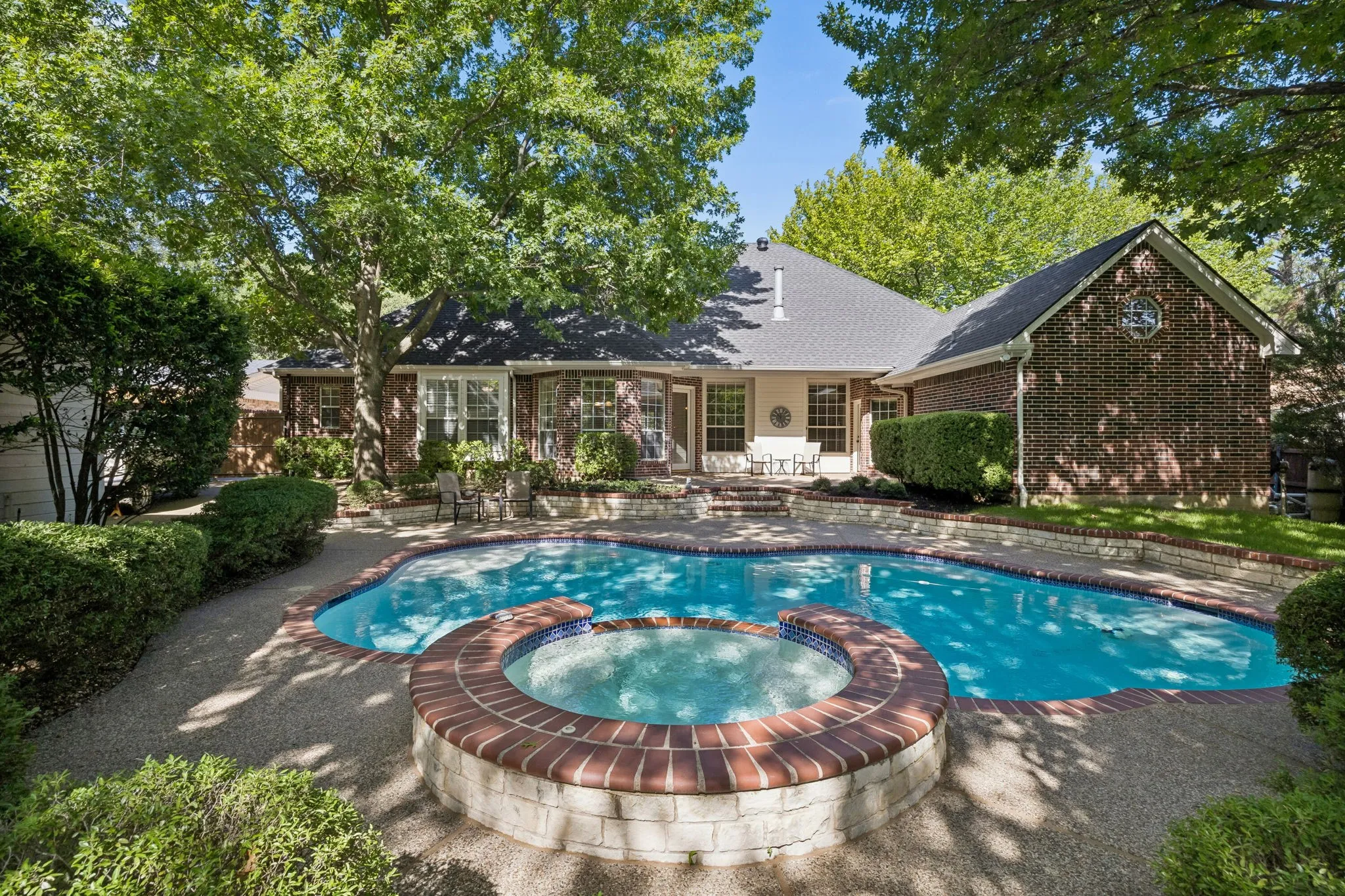 Outdoor living space with heated pool and spa and covered porch