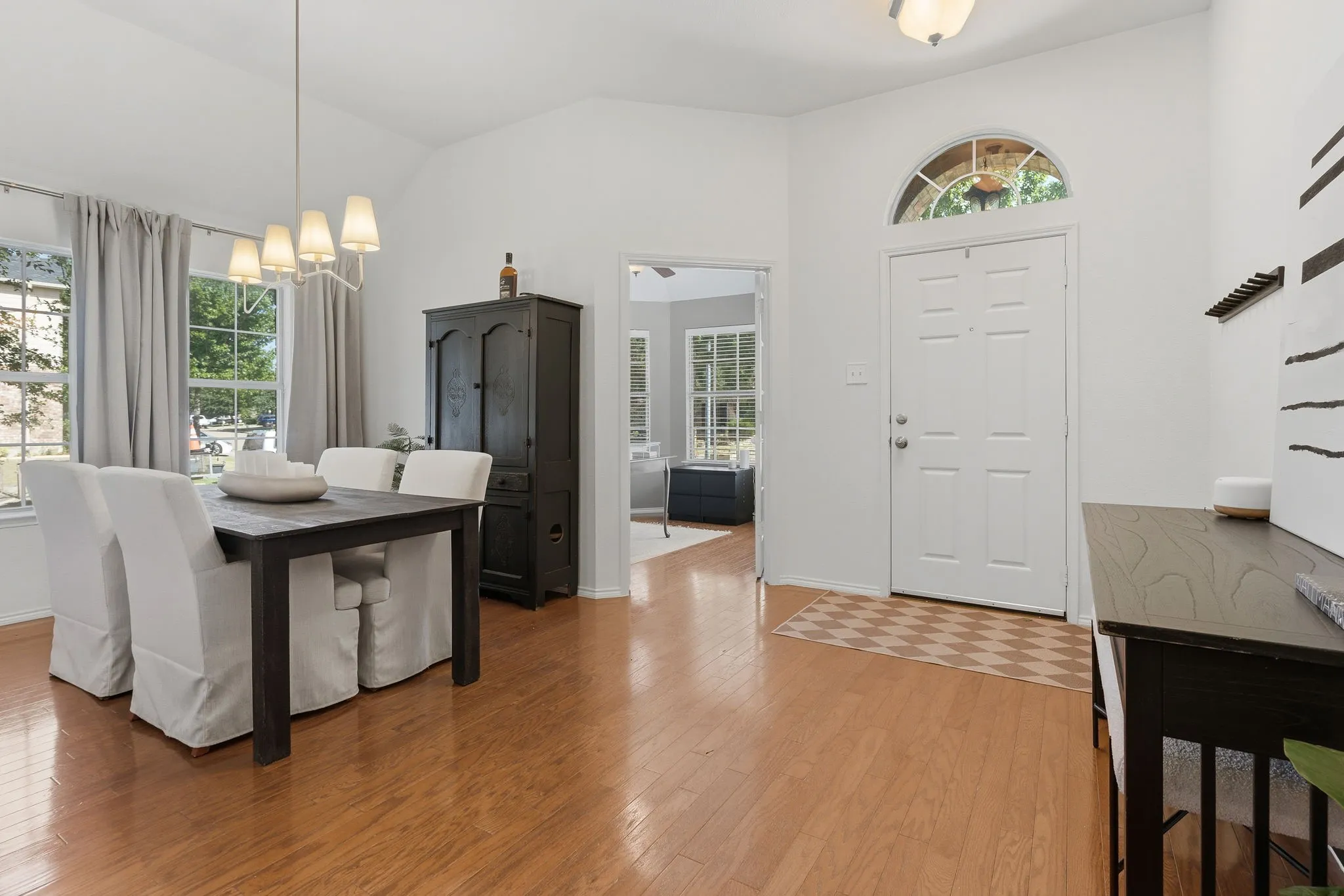 View from Foyer into the dining room which features new lighting, and office with French doors.