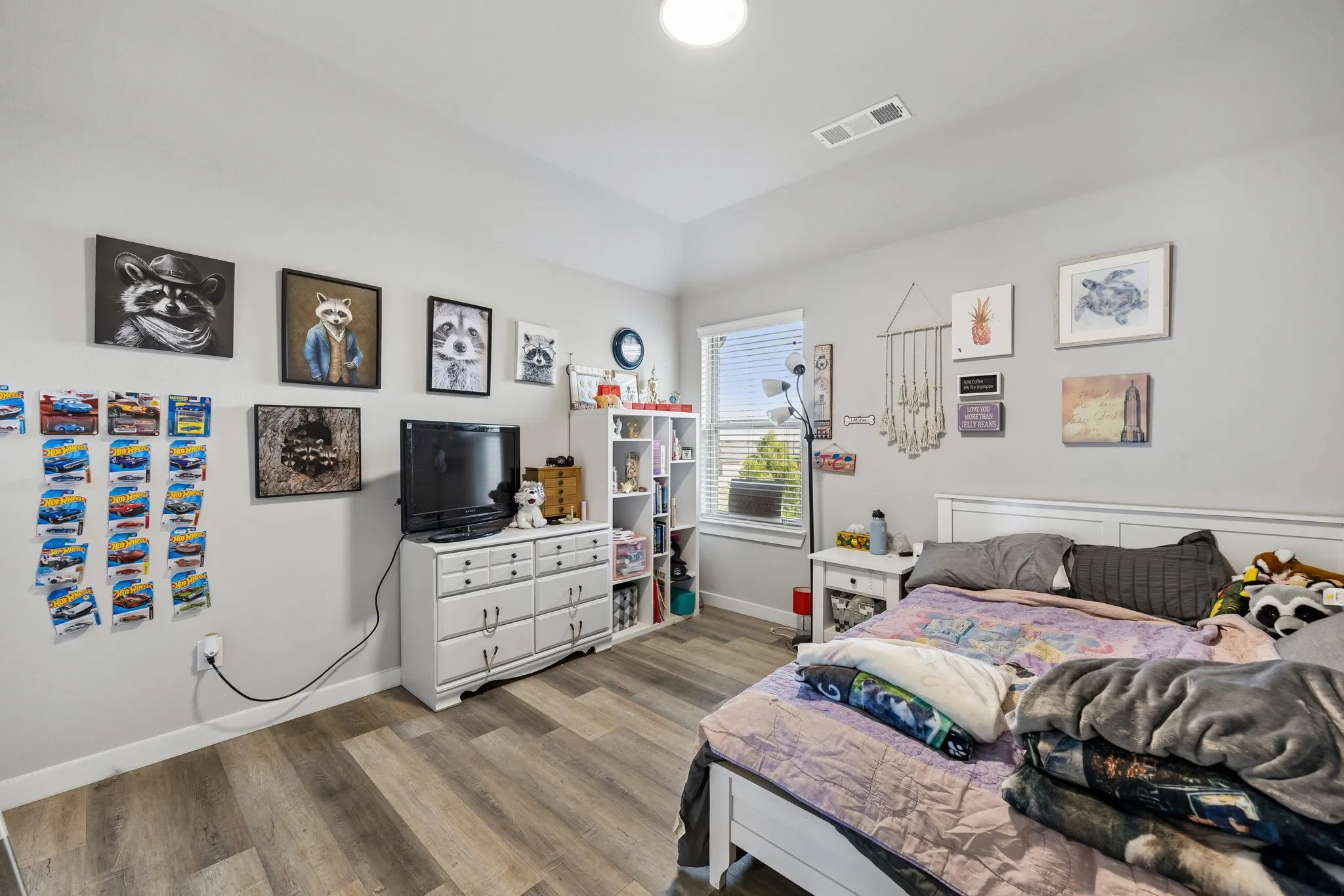 Wood-finish flooring, single window with horizontal blinds, built-in overhead light, white baseboards, and light gray wall paint