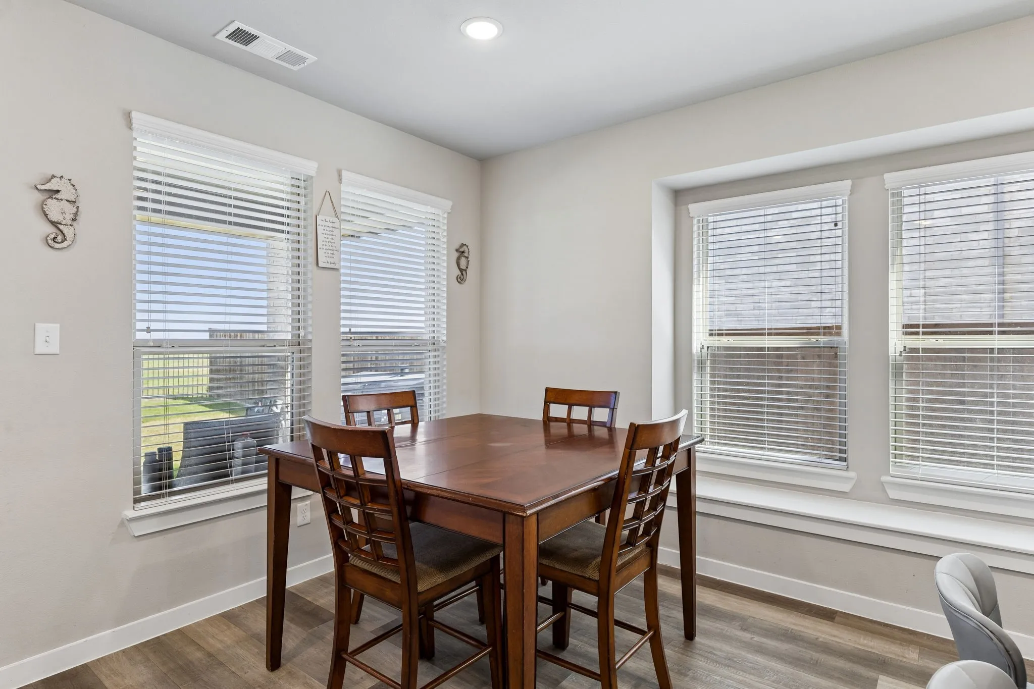 Wood-finish flooring with multiple windows and recessed lighting