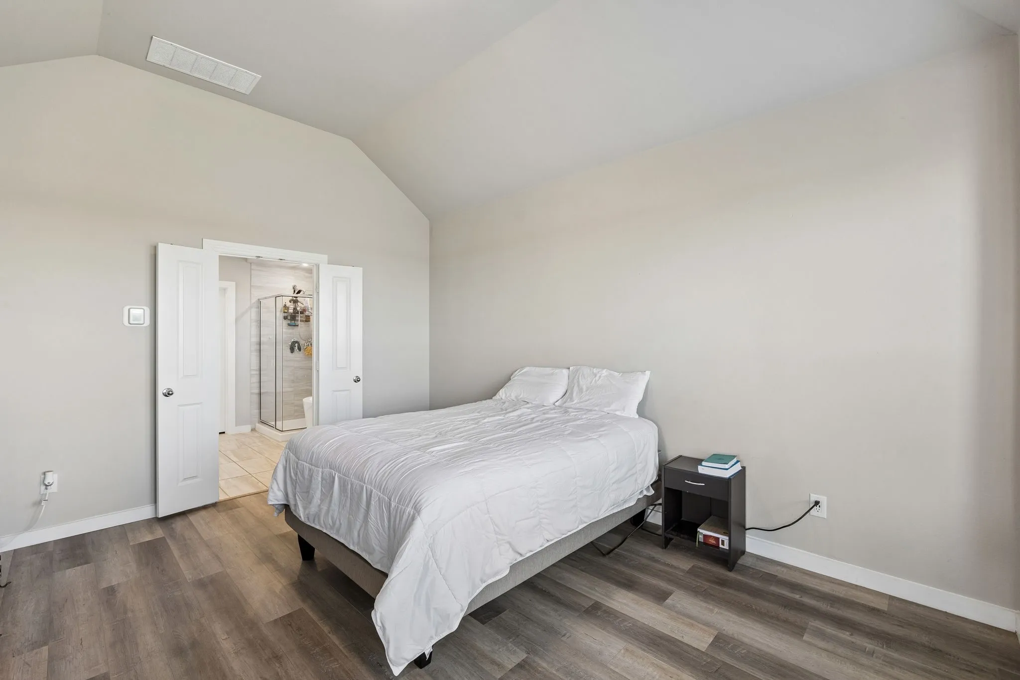 Vaulted ceiling, wood-finish flooring, light neutral wall paint