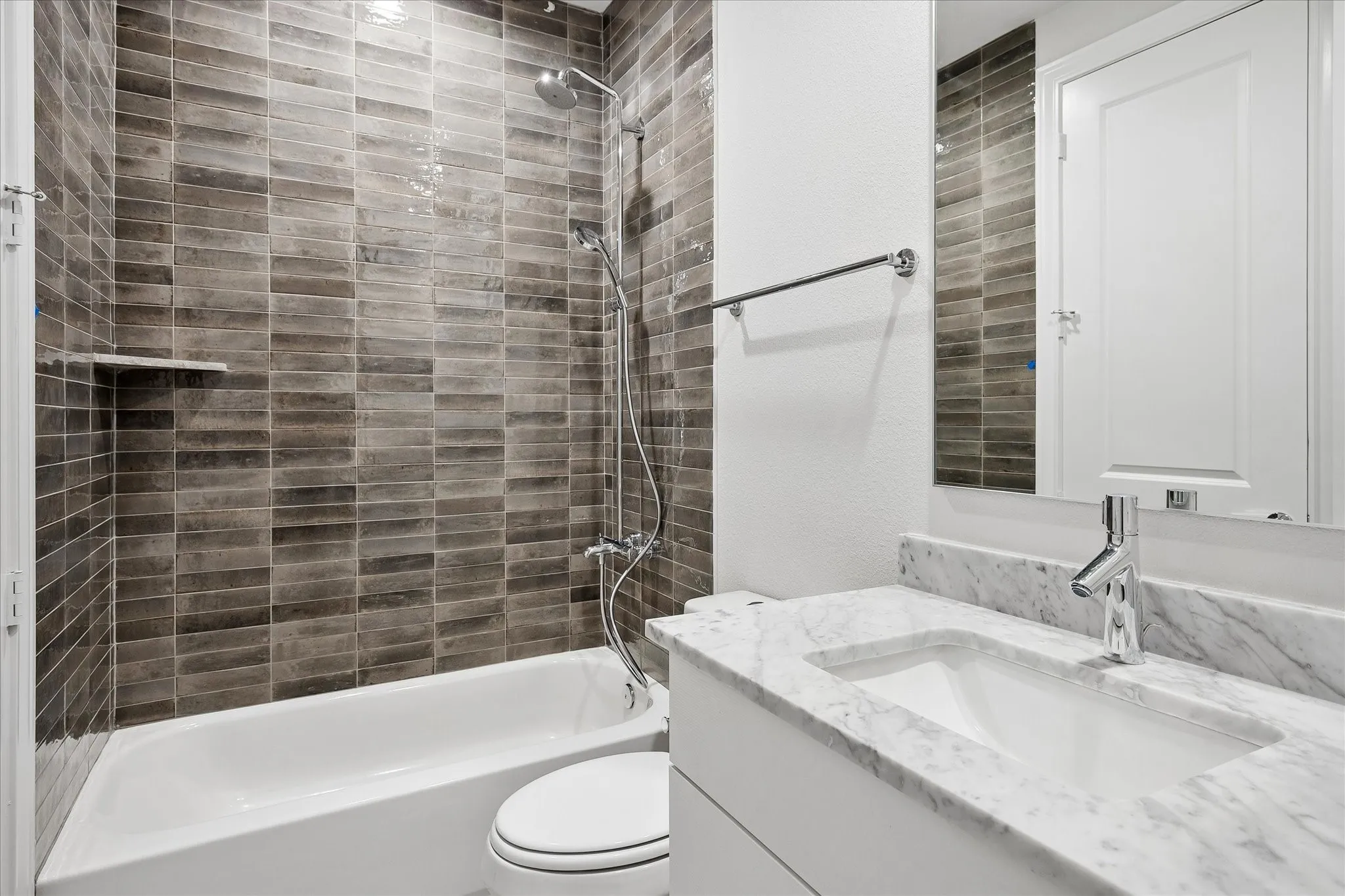 White vanity with a marble-finish countertop, integrated rectangular sink, and polished chrome faucet