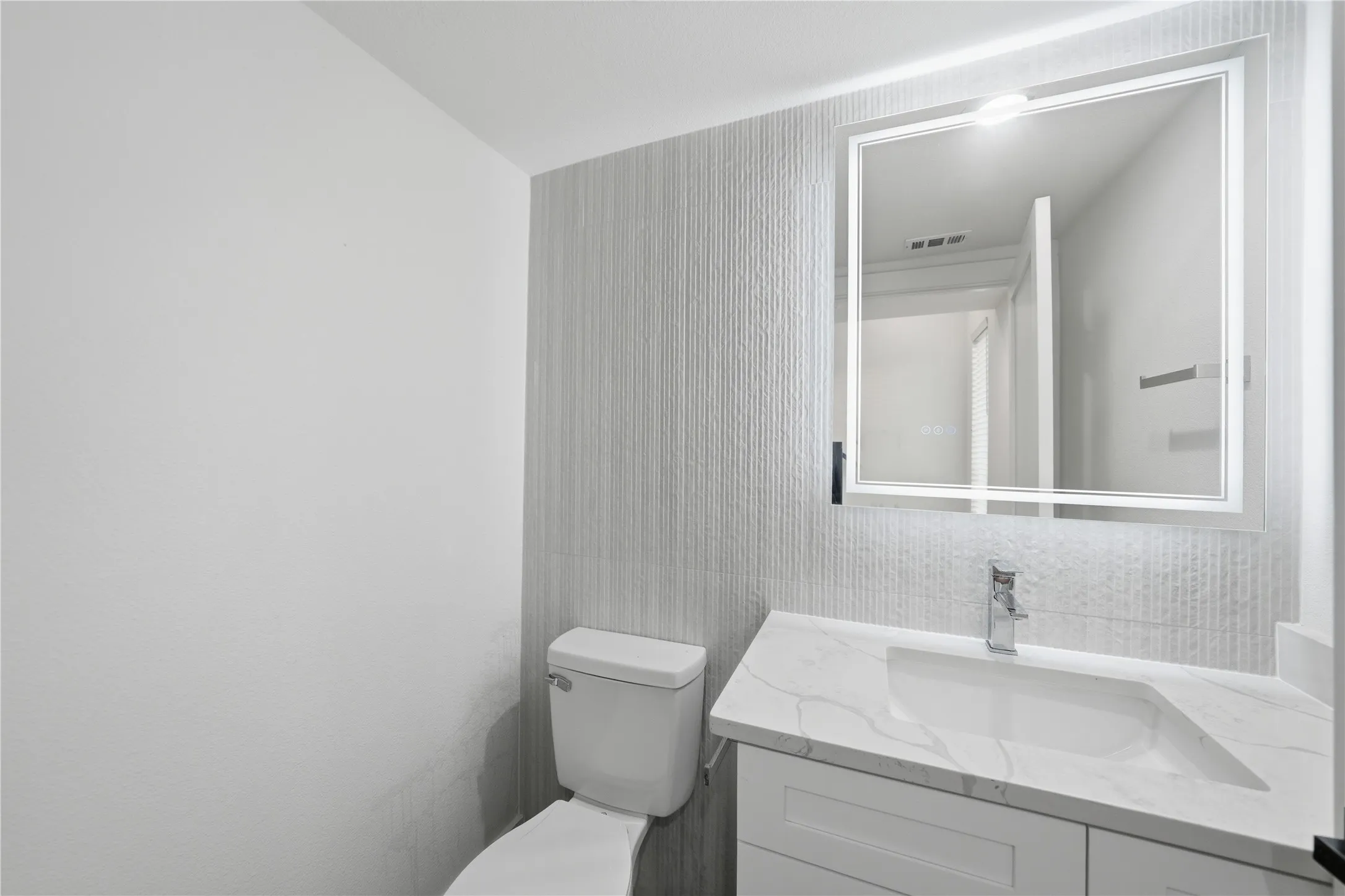 Modern vanity featuring a rectangular integrated sink, marbled countertop, and chrome faucet