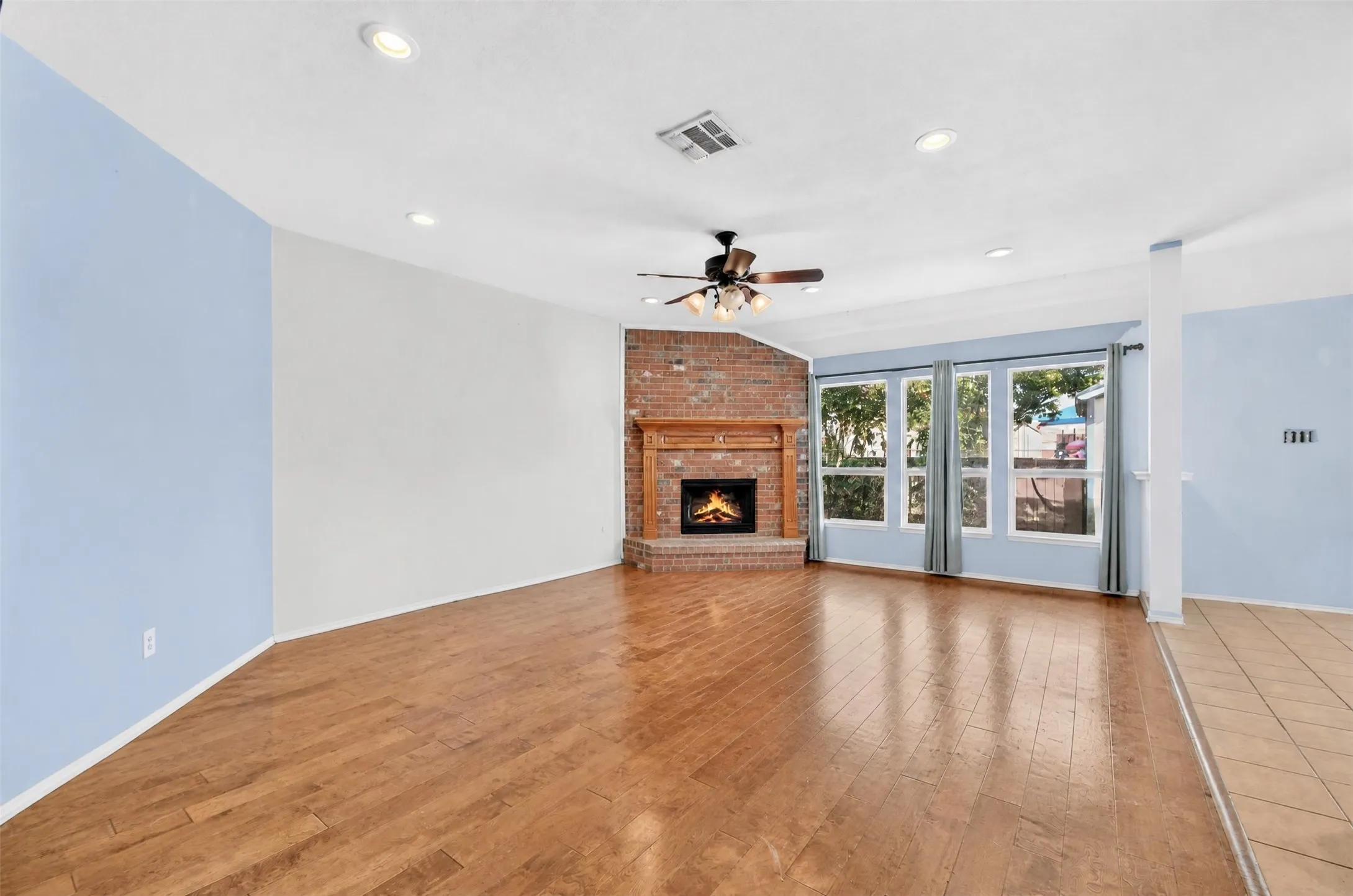 Another view of the Living Room and corner wood burning fireplace.