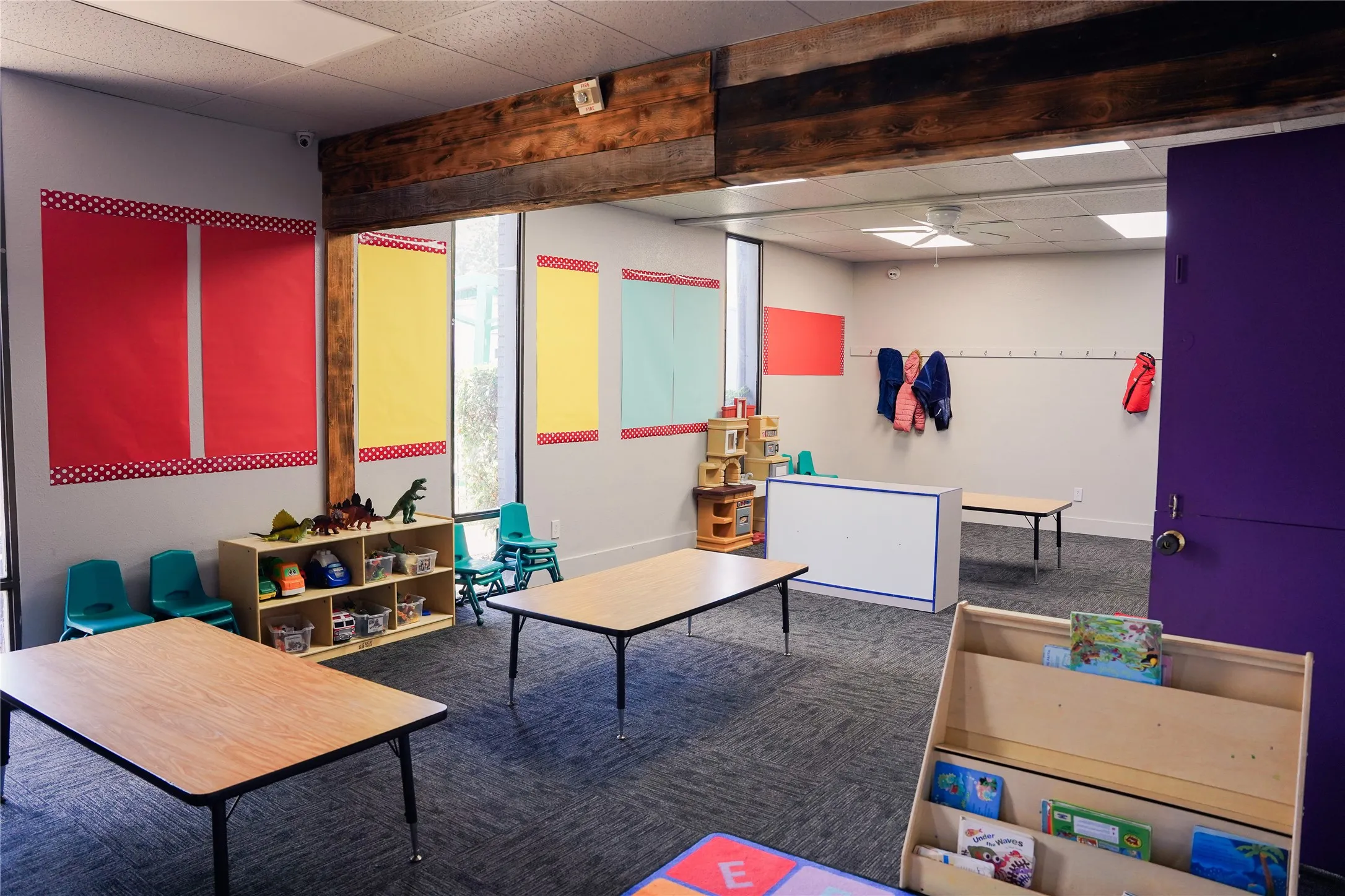 Open-plan interior with exposed ceiling beam, recessed lighting, and carpeted flooring
