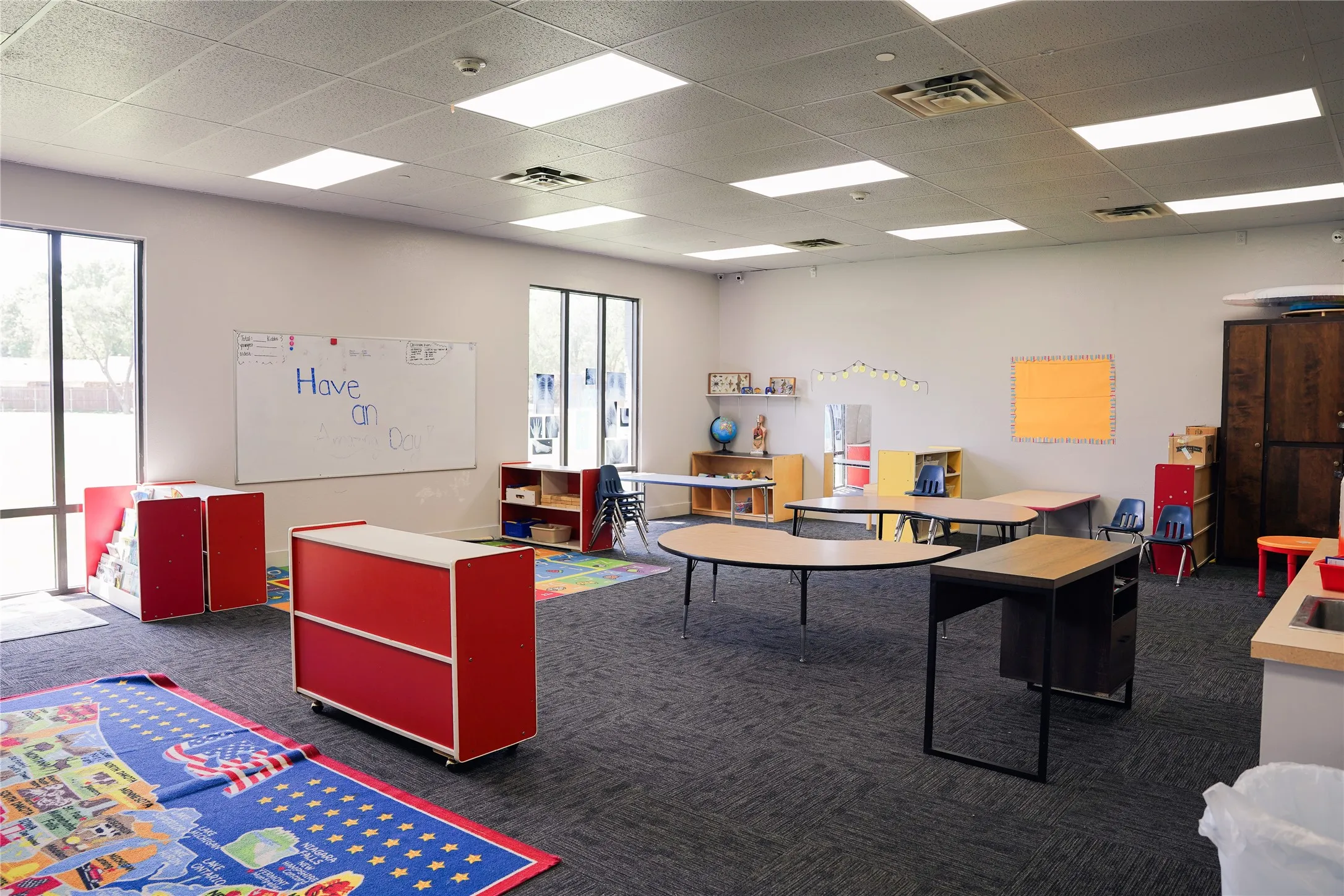 Spacious room featuring broad windows, recessed lighting, drop ceiling, and dark gray carpeting