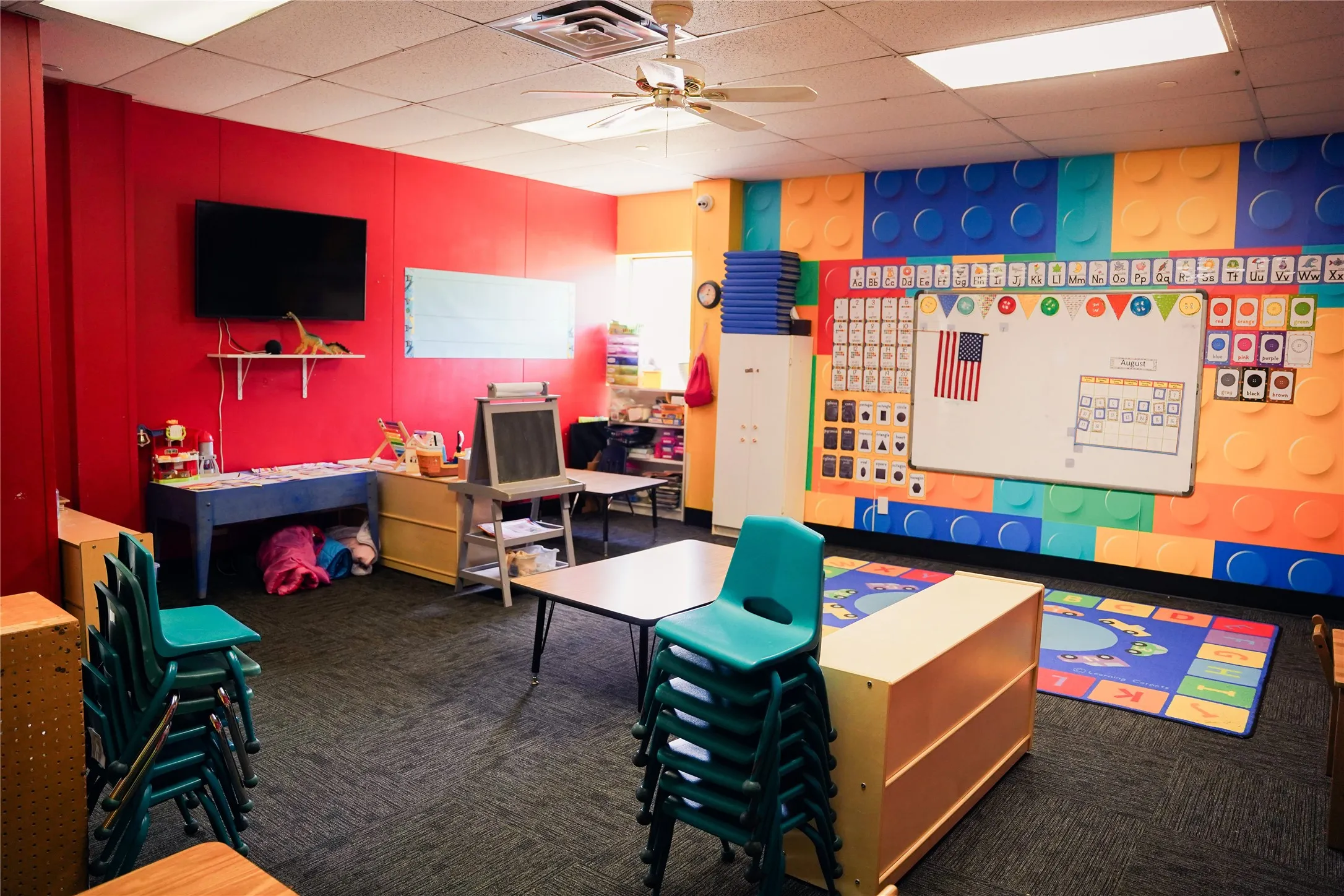 Wall-mounted television, ceiling fan, recessed lighting, and wall-to-wall carpeting