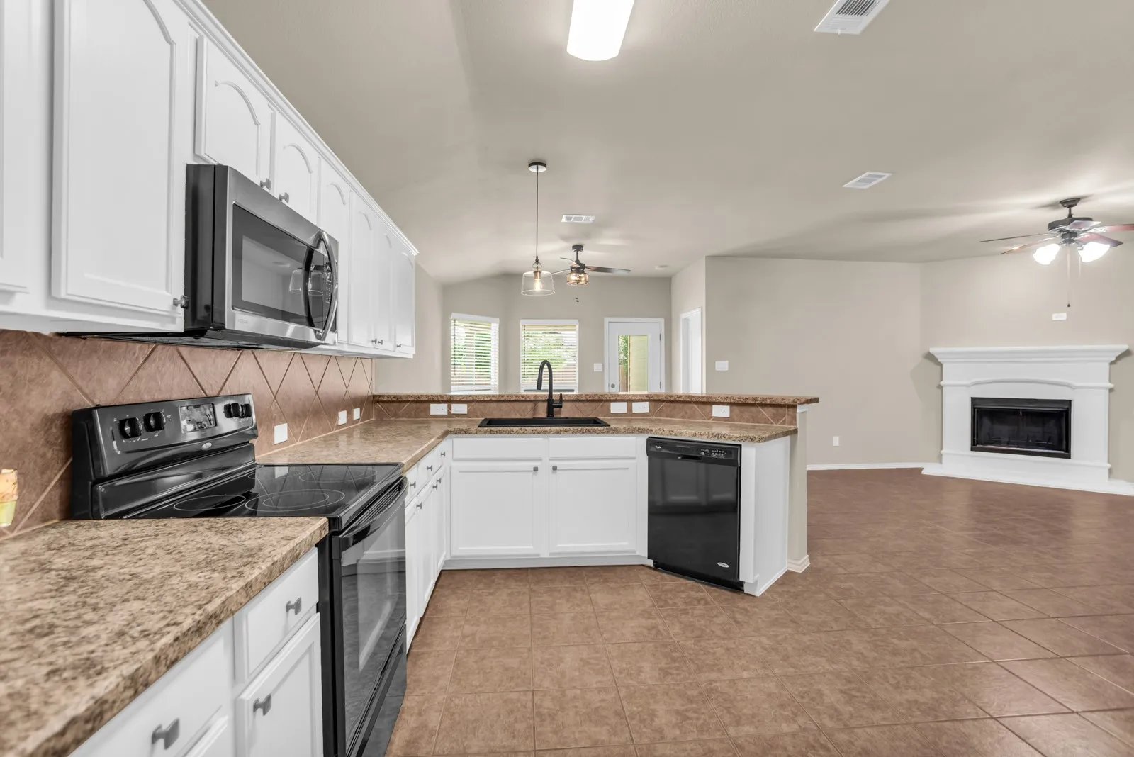 Kitchen featuring white cabinetry, a built-in microwave, tiled backsplash, and a breakfast bar