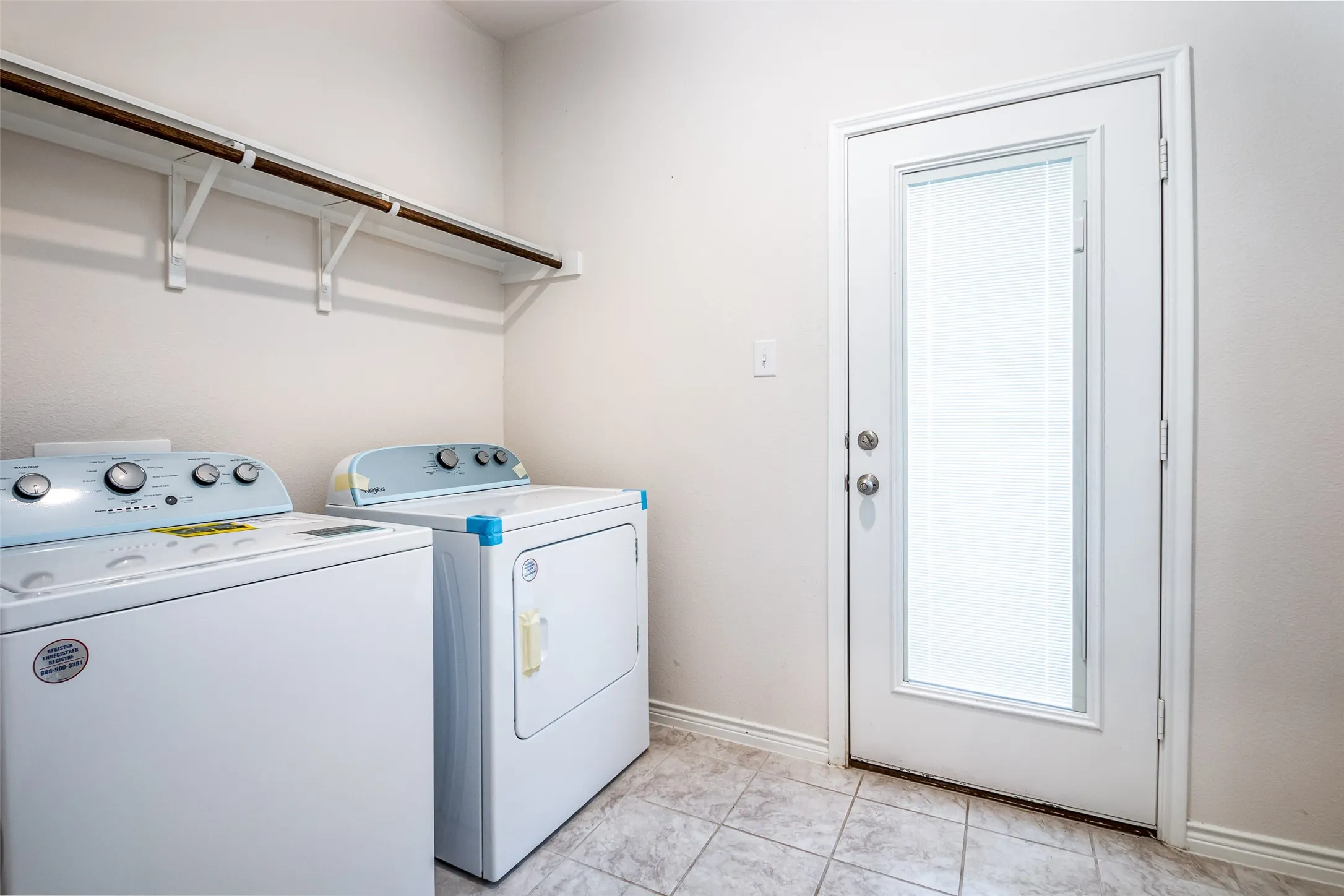 Laundry area featuring tile flooring, white walls, and an exterior door with an inset window