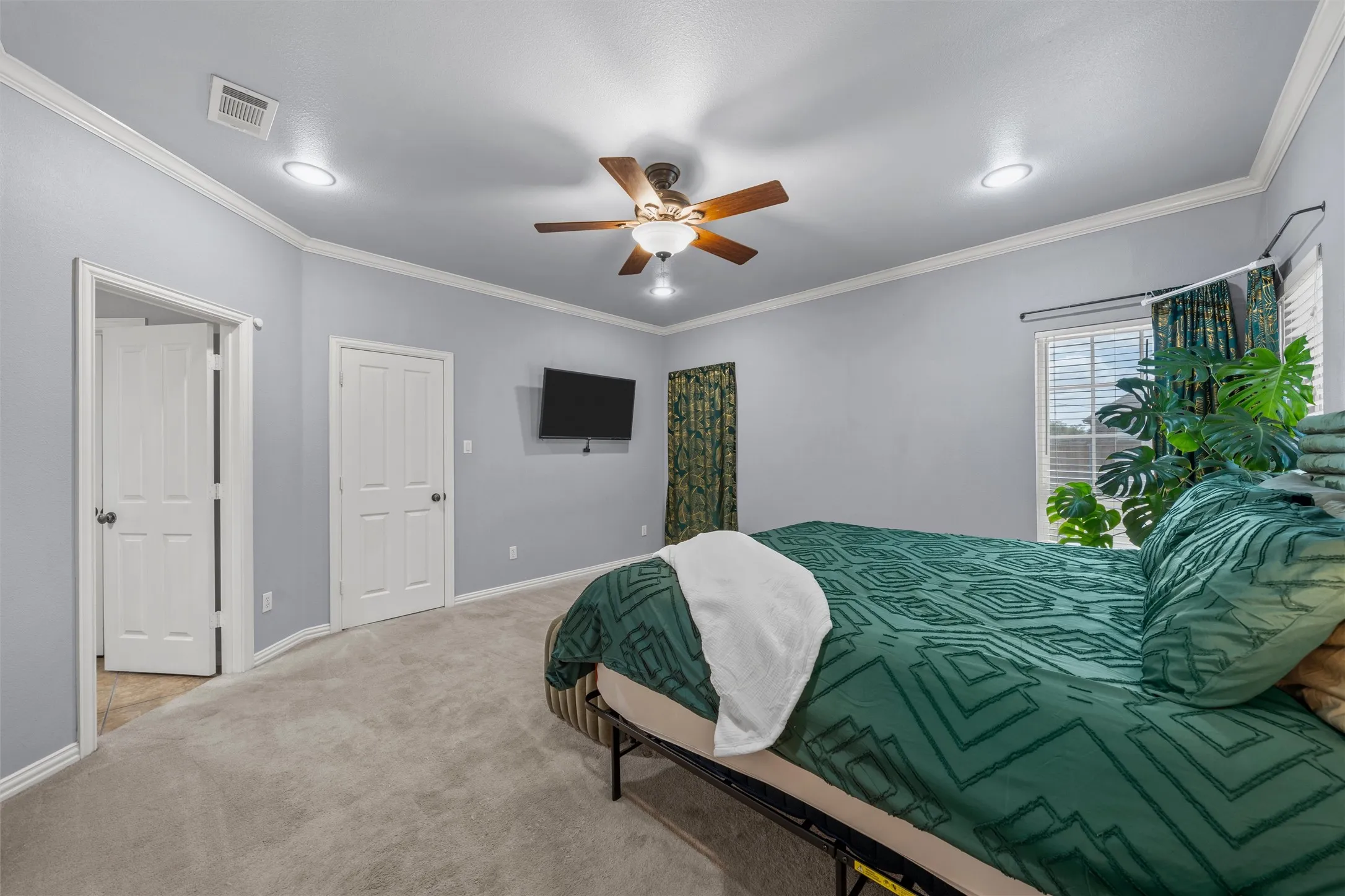 Recessed lighting, ceiling fan, crown molding, paneled interior doors, and window with blinds