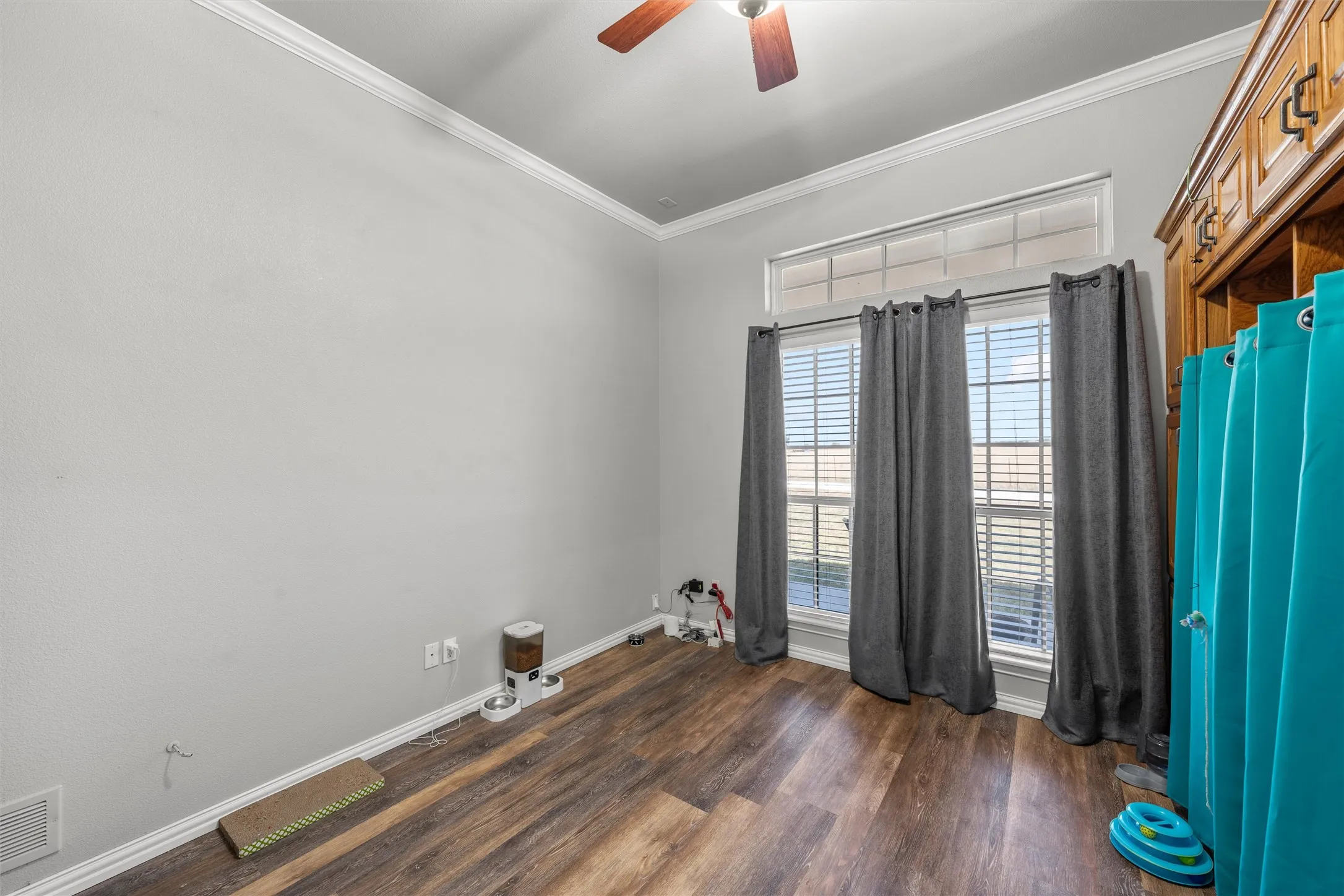 Vaulted ceiling, crown molding, wood-finish flooring, transom window, and built-in wood cabinetry
