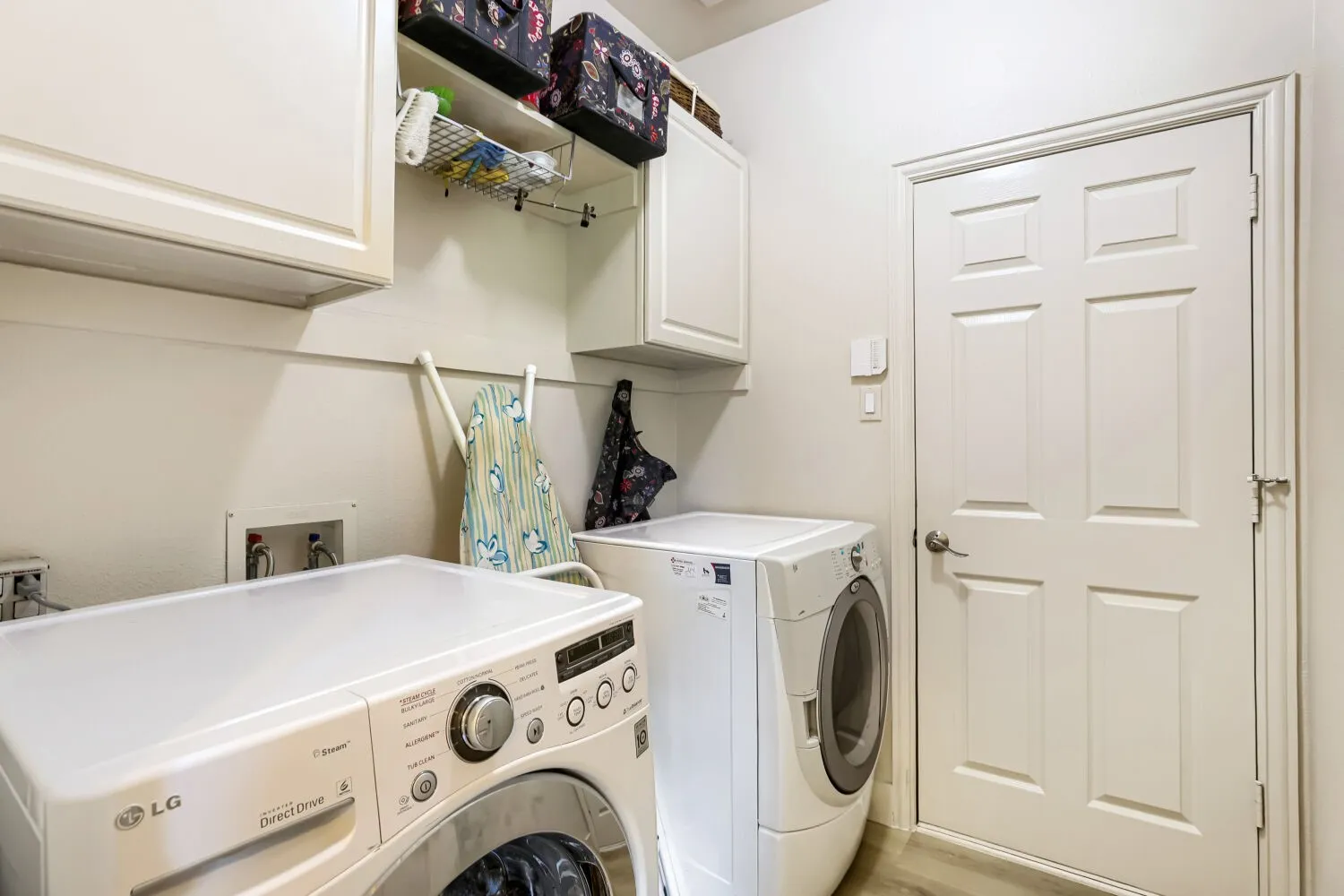 Laundry room for a full-size washer, dryer, and ample storage space.