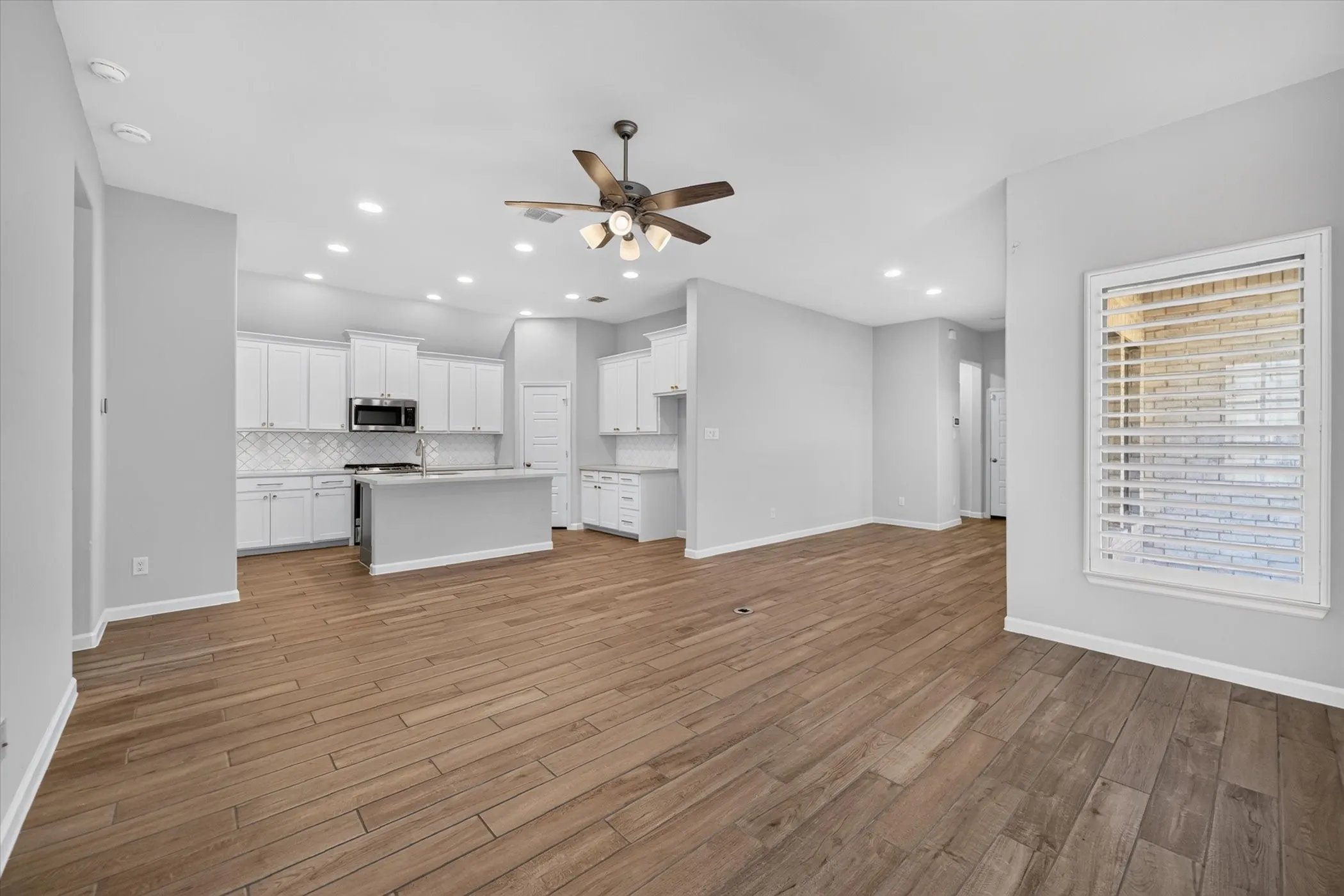 Open concept living area featuring wood-finish flooring, recessed lighting, and a ceiling fan