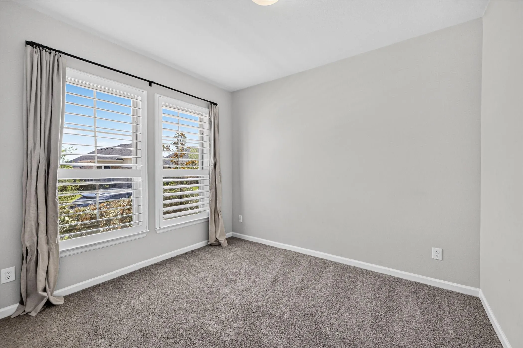 Dual windows with white plantation shutters