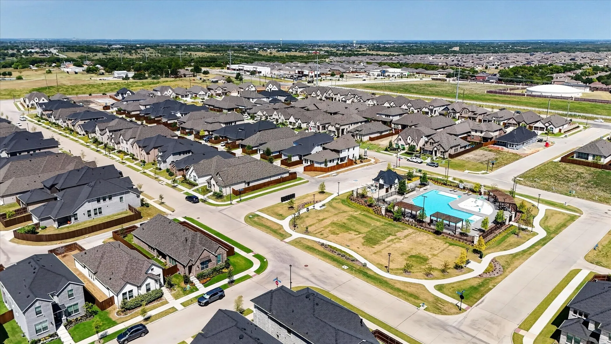 Community features include a swimming pool, multiple residential structures, paved streets, and landscaped common areas