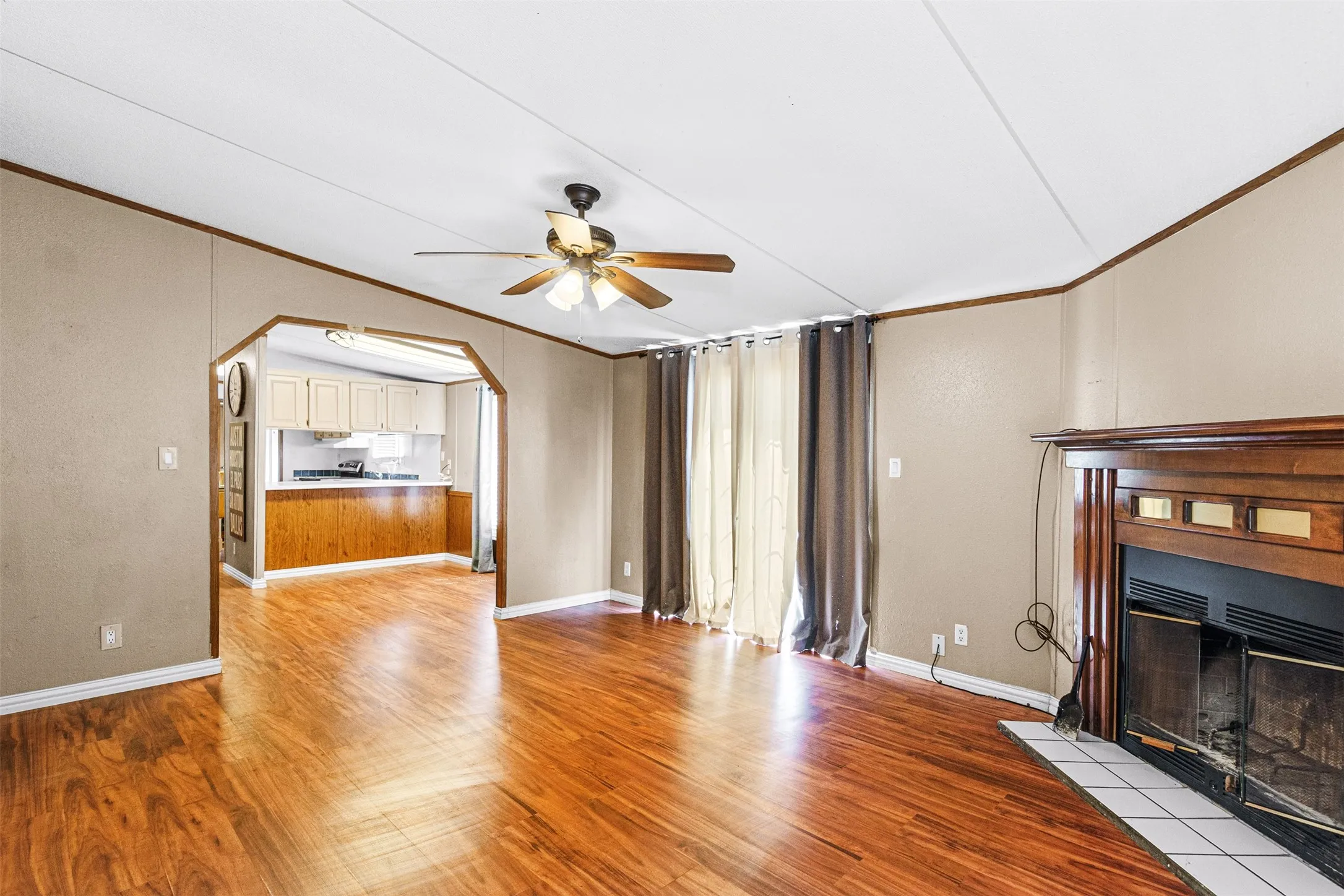Wood-finish flooring throughout, featuring a fireplace with a wood mantel