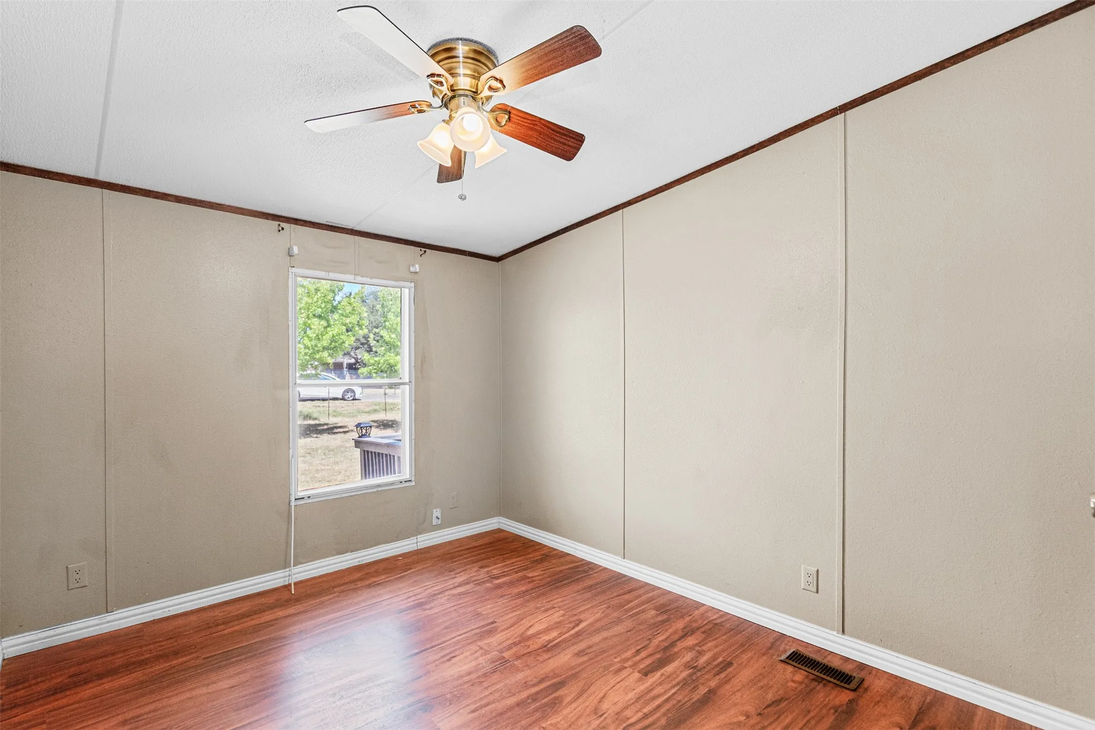 Wood-finish flooring with a ceiling fan light fixture