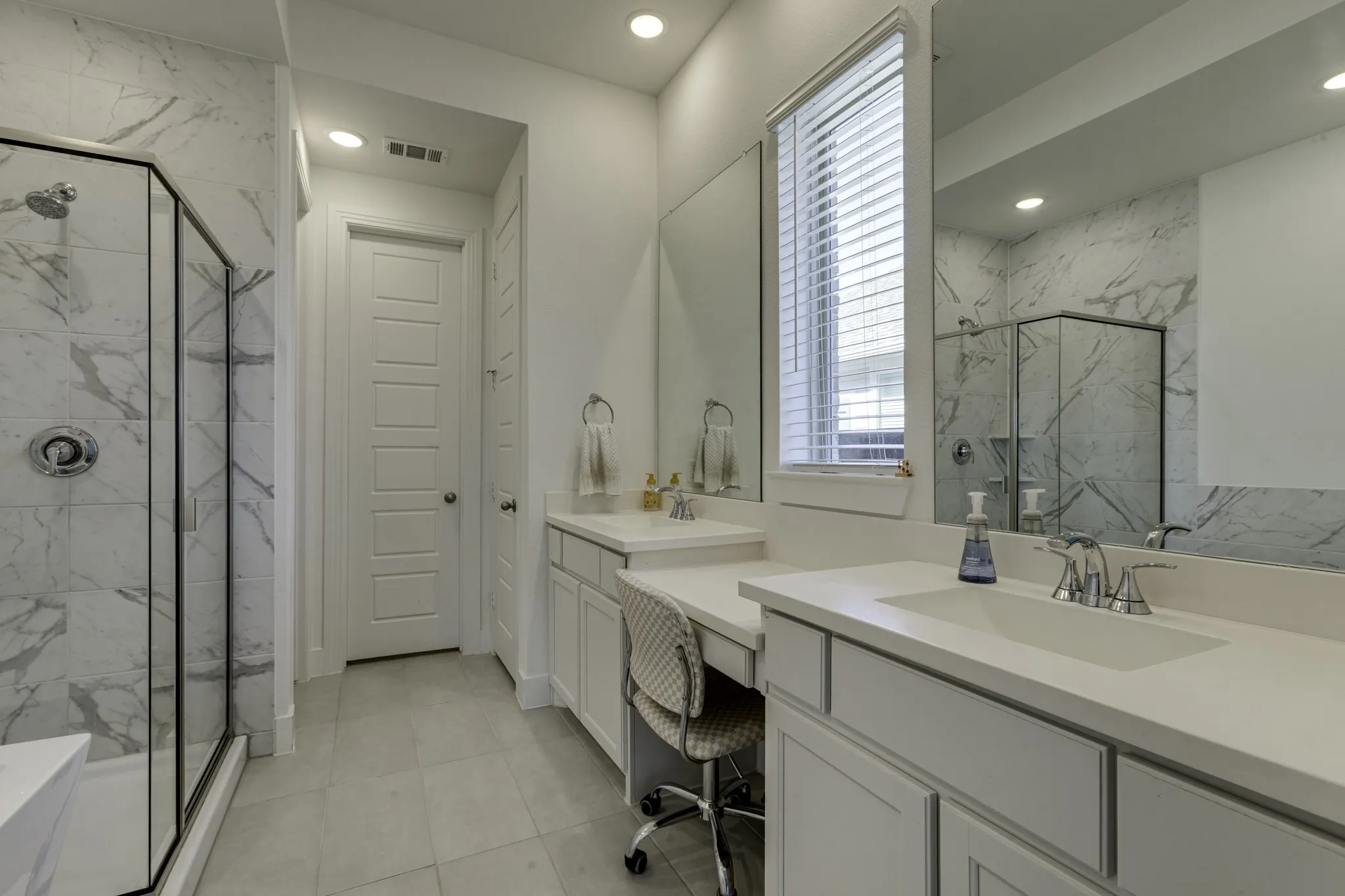 Glass-enclosed shower with marble-style tile surround