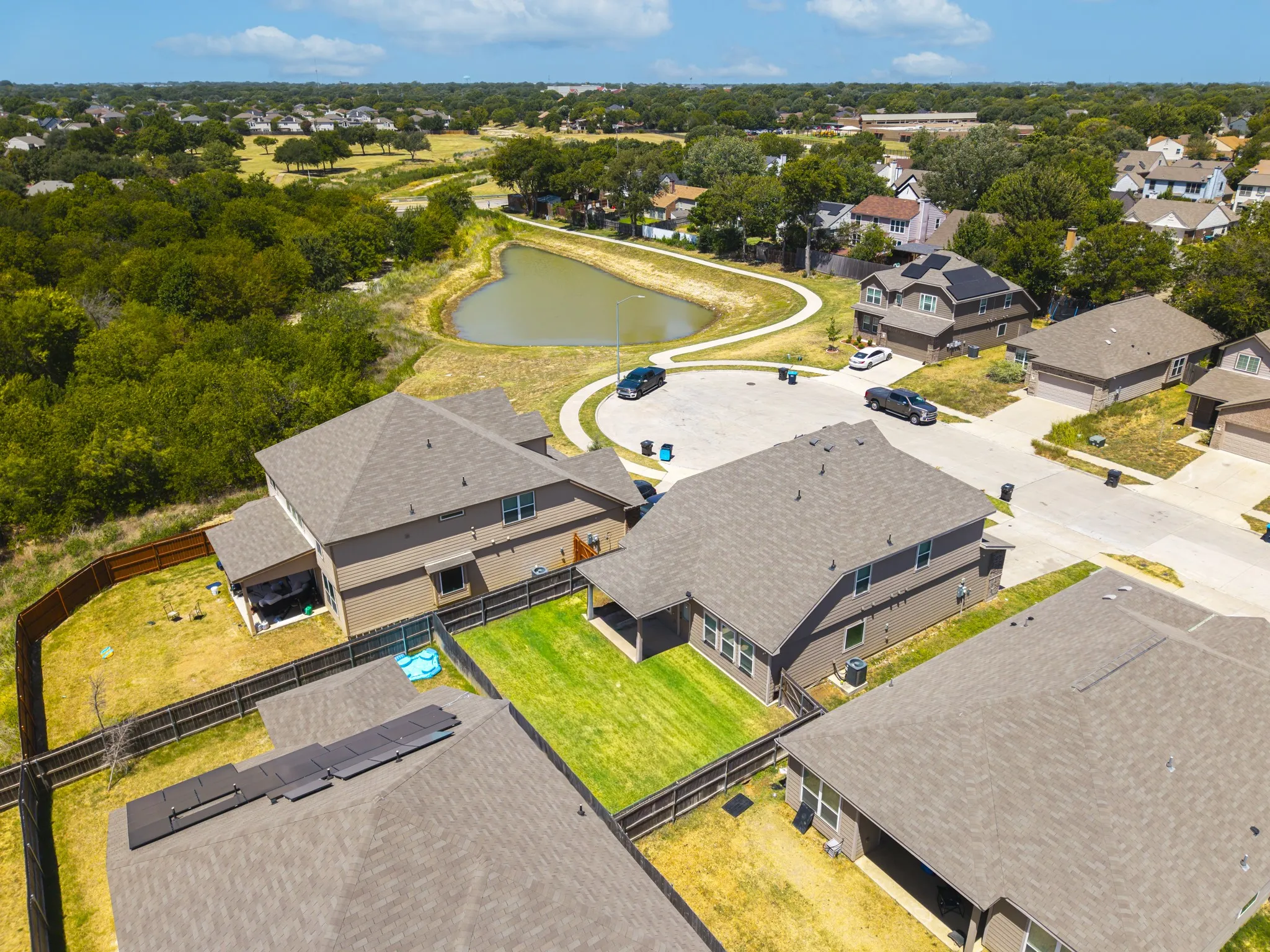Community with a heart-shaped pond, mature trees, and residential streets