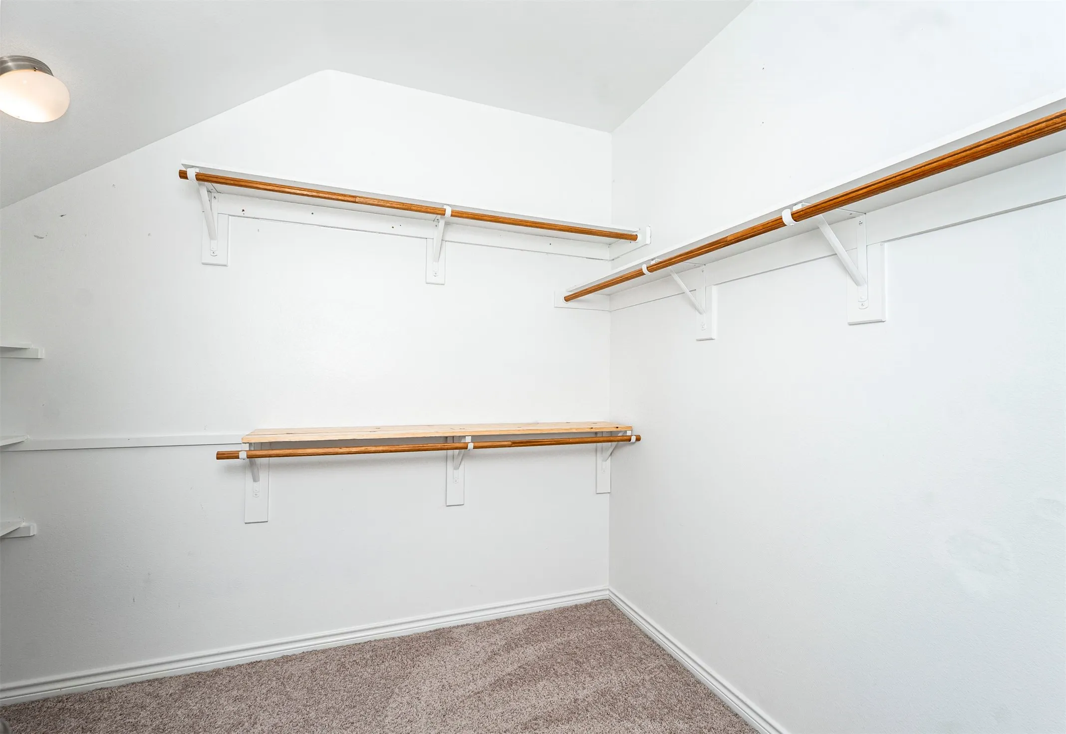 Carpeted flooring, built-in shelving, angled ceiling, and flush mount ceiling light