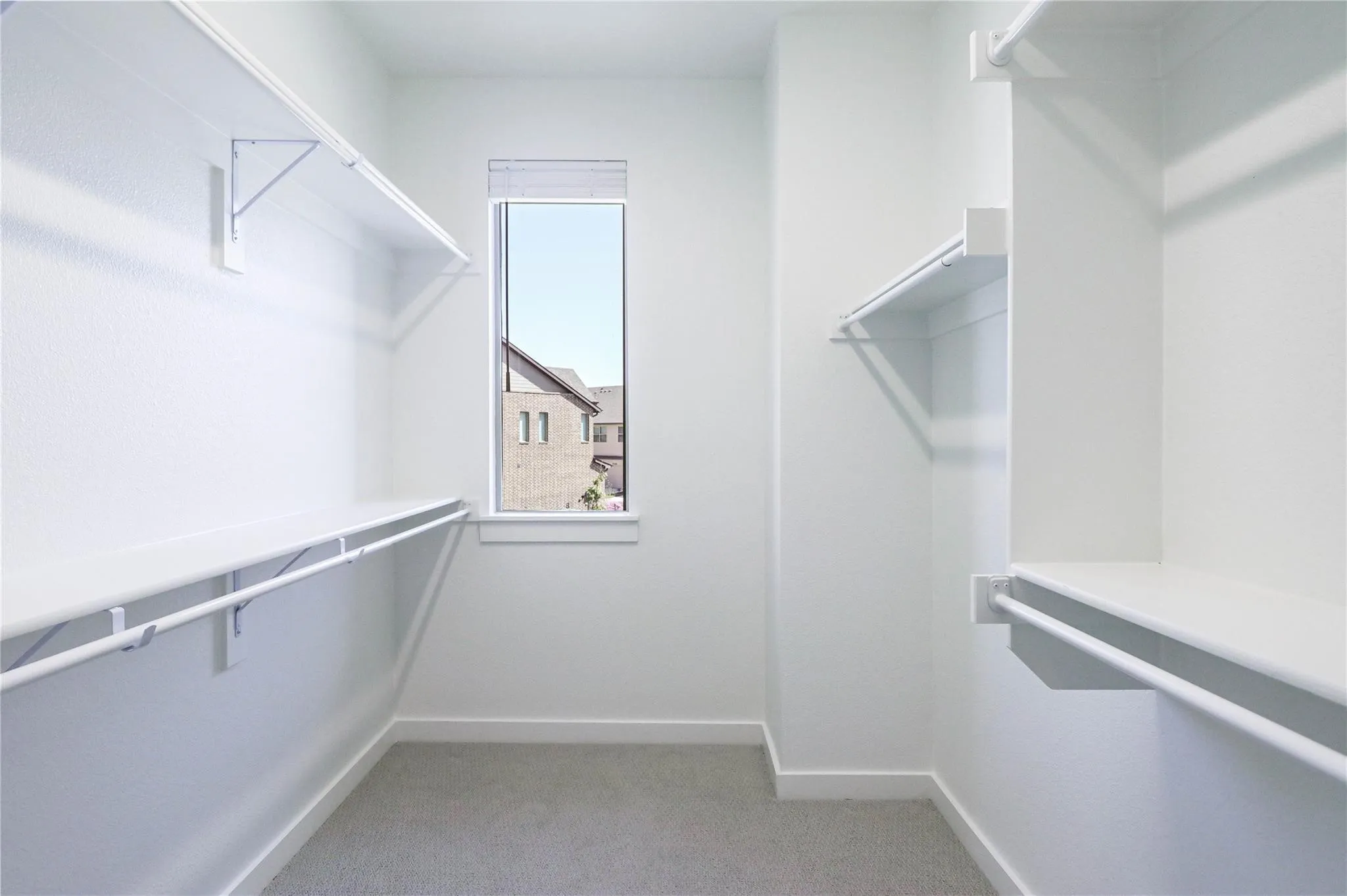 Walk in closet with light carpet
