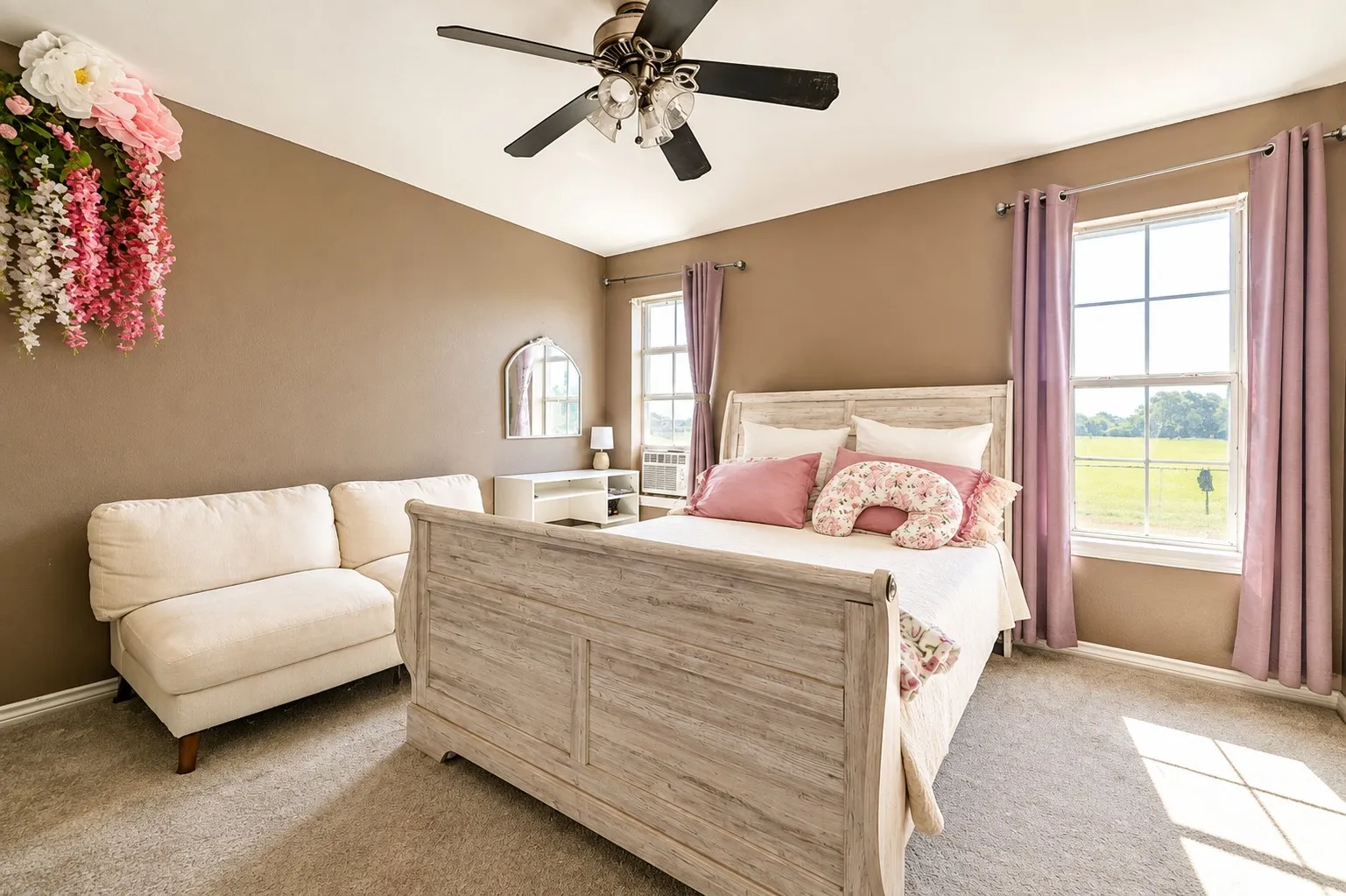 Carpeted flooring, ceiling fan, and two large windows with horizontal mullions