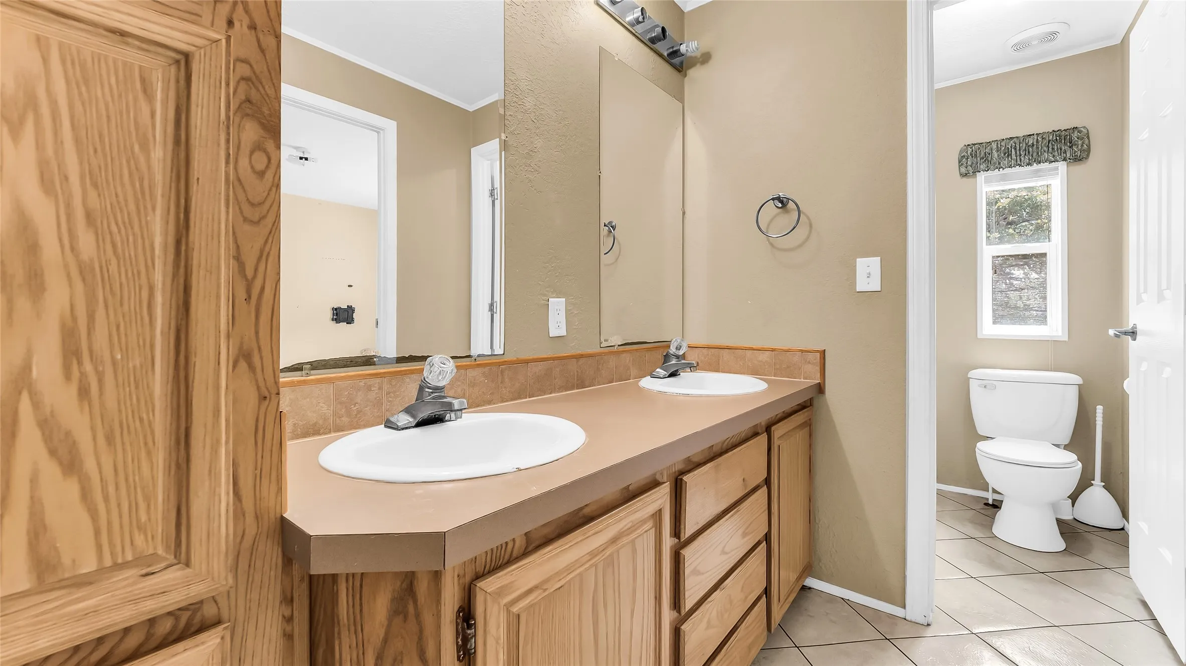 Dual basin vanity with wood-finish cabinetry and integral sink