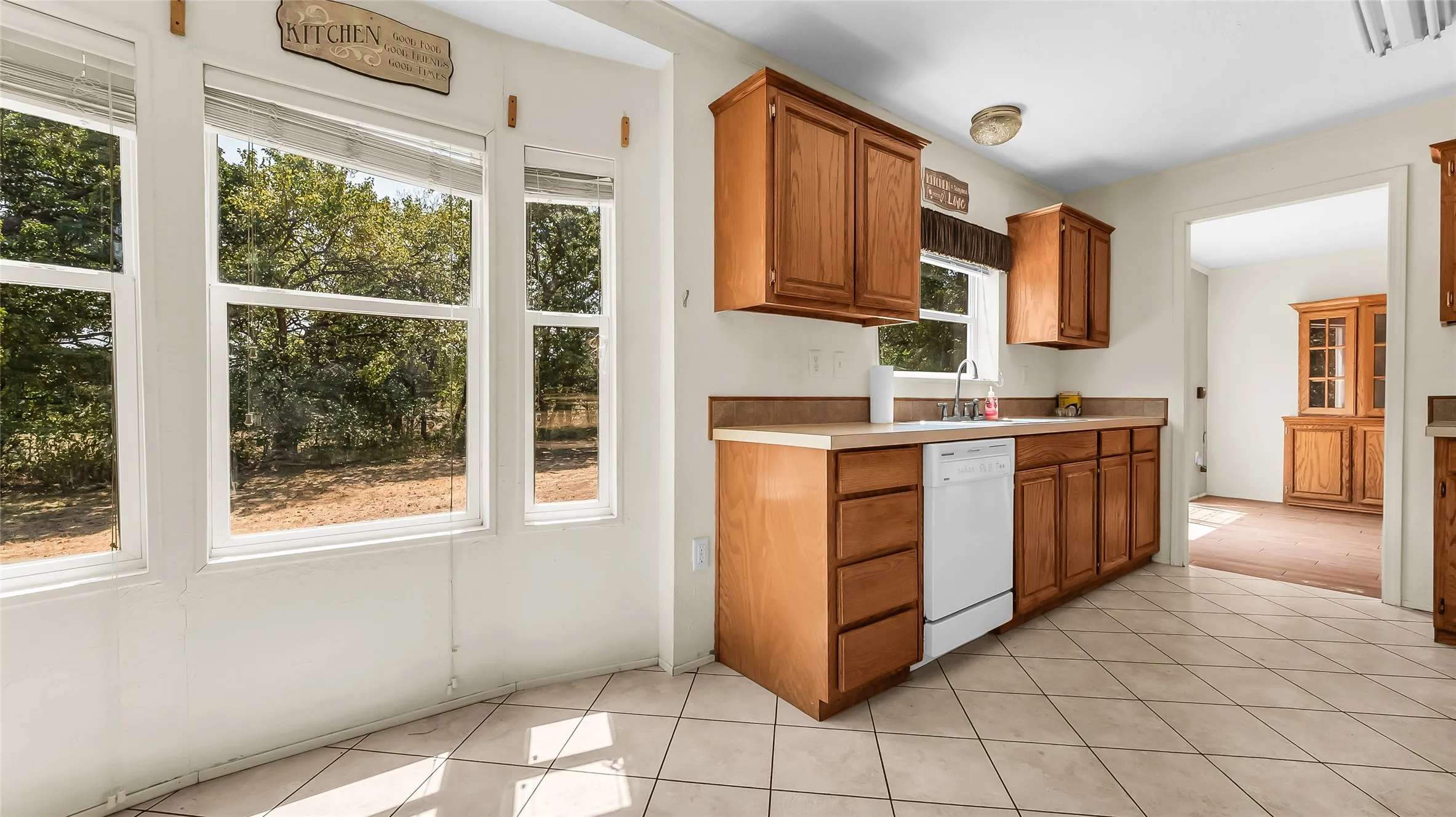 Kitchen featuring wood-finish cabinetry, light-toned countertops, and tile flooring