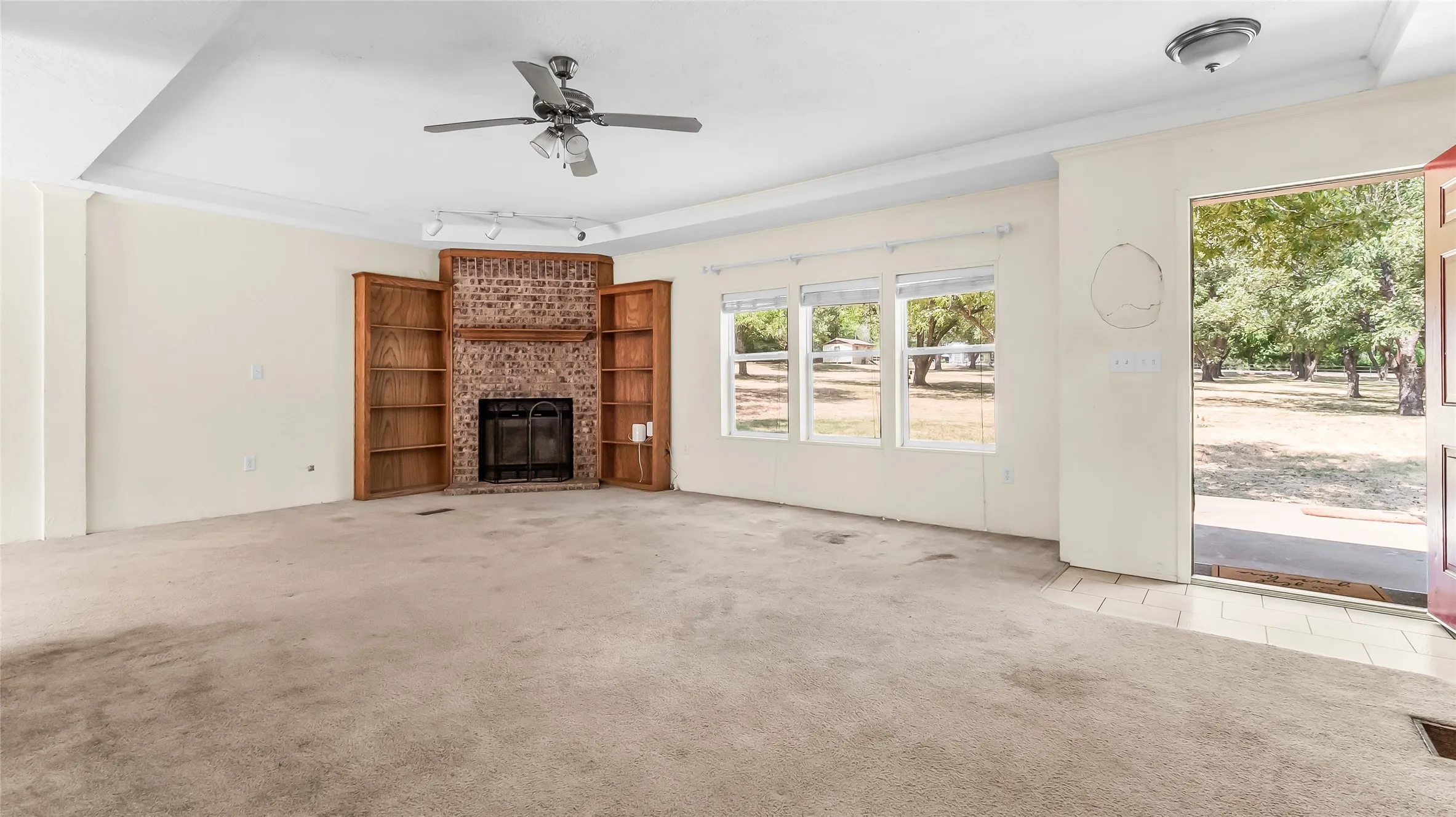 Brick fireplace with a wood-finish mantel and built-in shelving