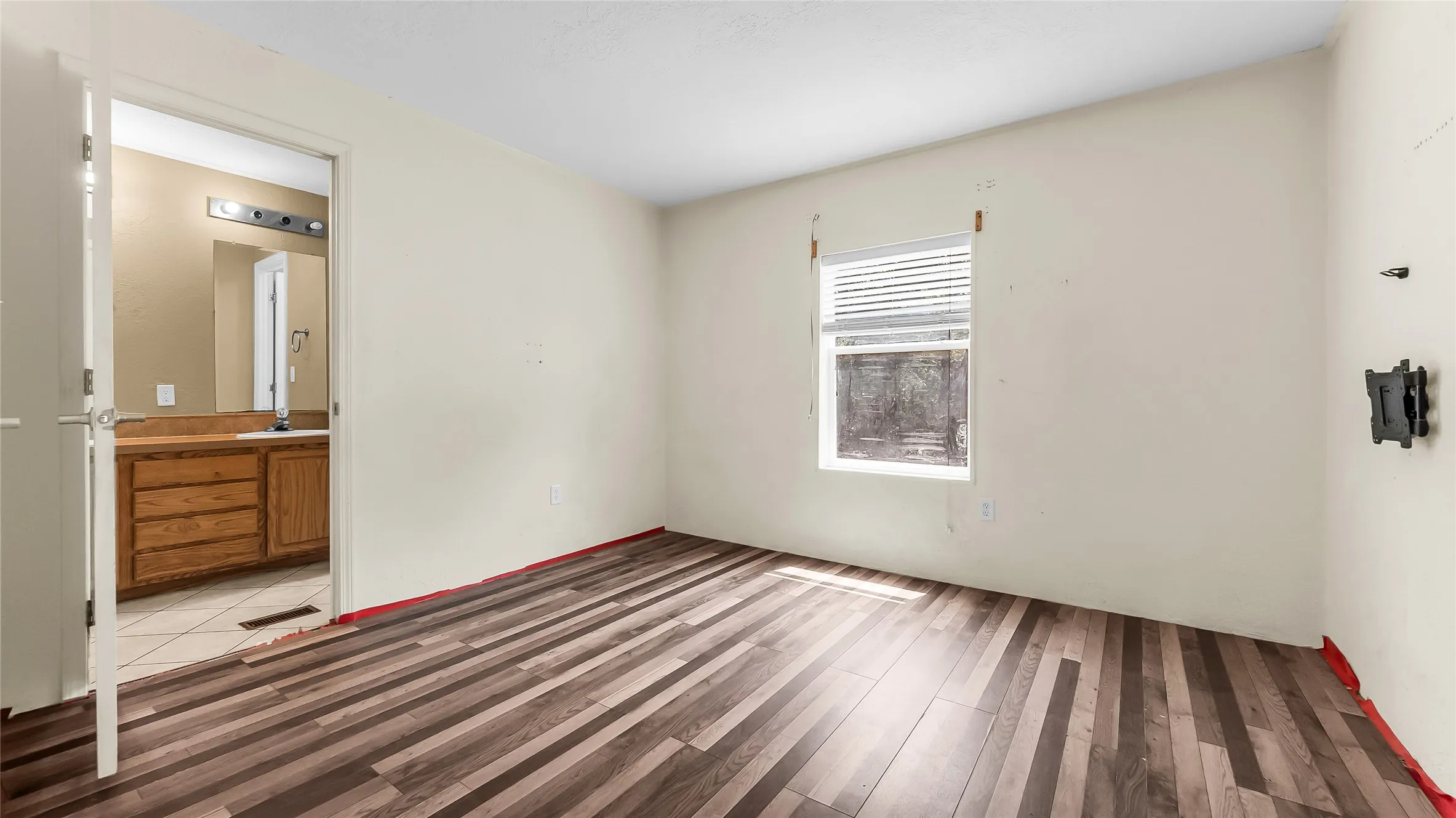 Wood-finish flooring, neutral wall tones, and a window with blinds