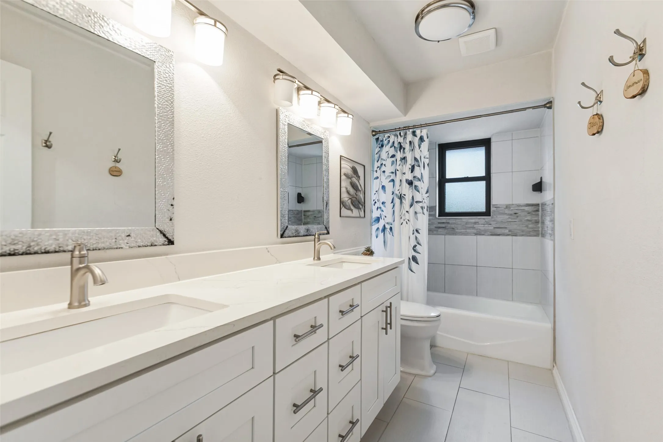 Dual vanity with integrated sinks, brushed nickel fixtures, and white cabinetry