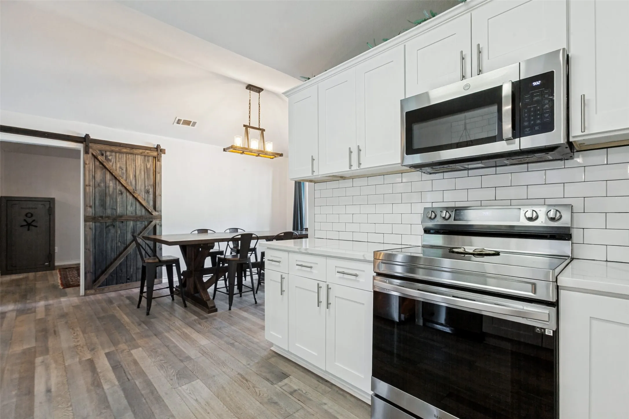 Modern kitchen with white cabinetry and stainless steel appliances