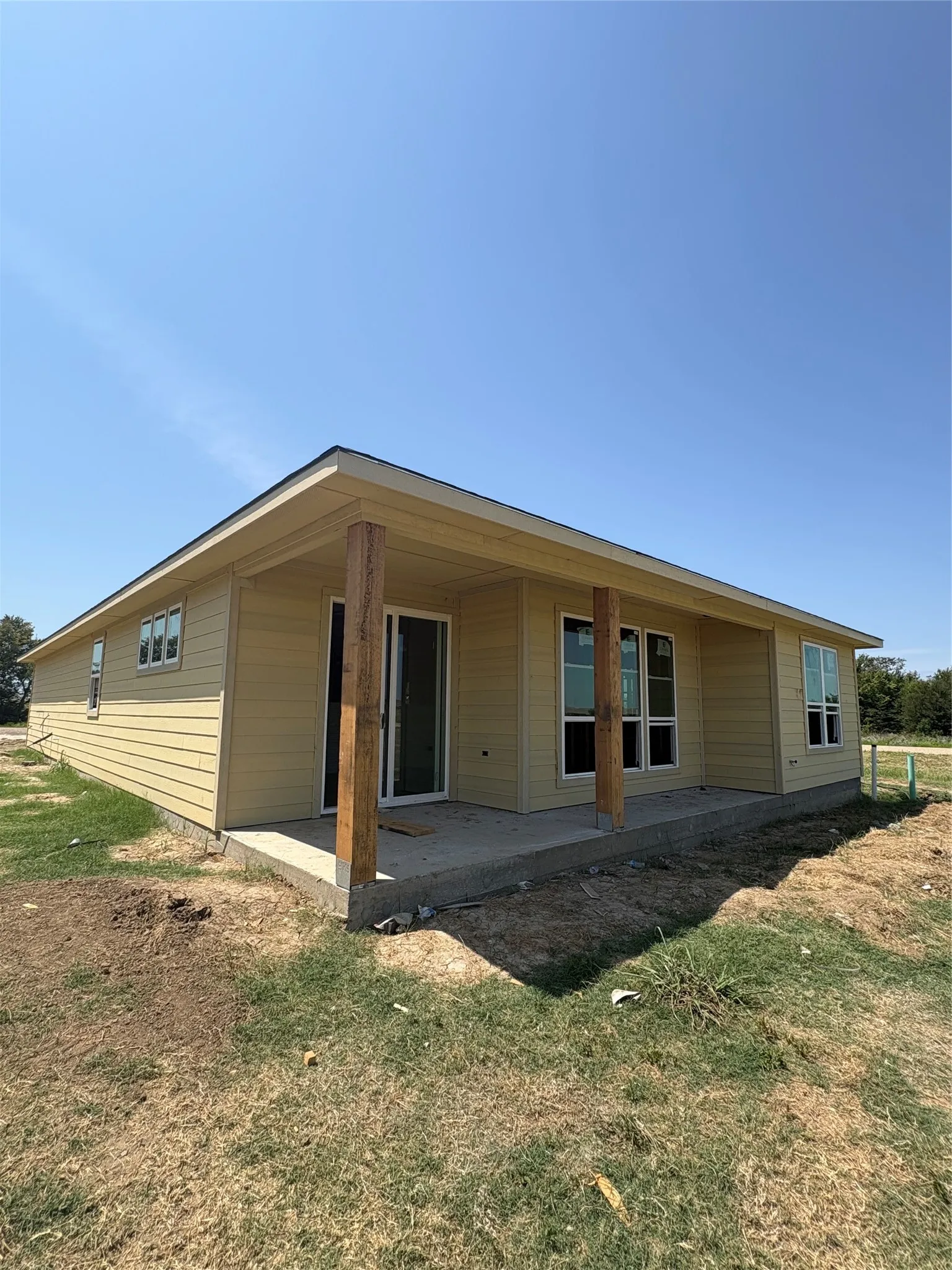 Rear exterior with a covered patio, multiple windows, and a sliding glass door