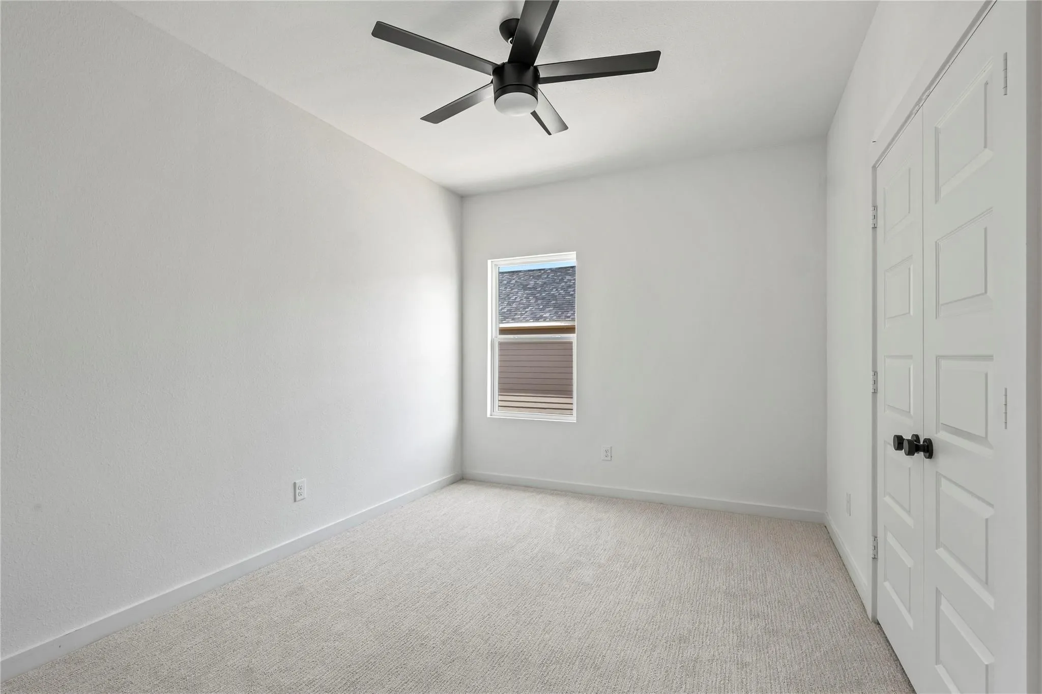 Recessed window, ceiling fan with light fixture, carpeted flooring, and paneled closet doors with black hardware
