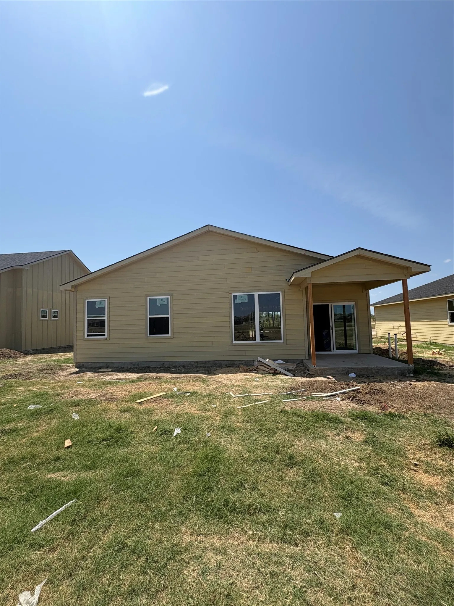 Rear exterior with light-colored siding and multiple windows