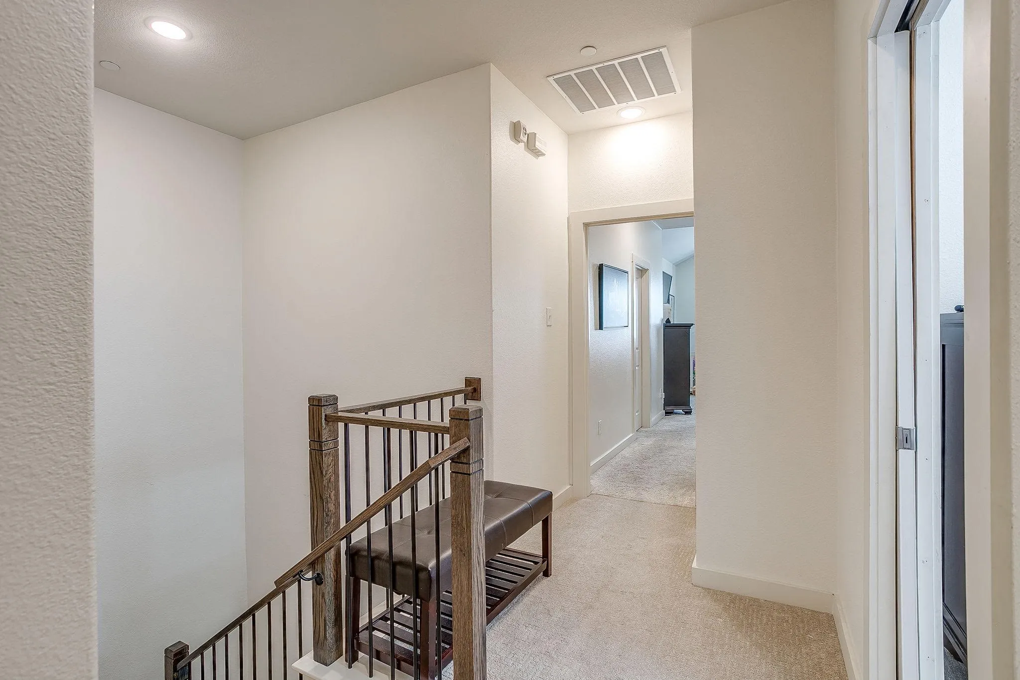 Staircase with wood-finish handrail and black metal spindles
