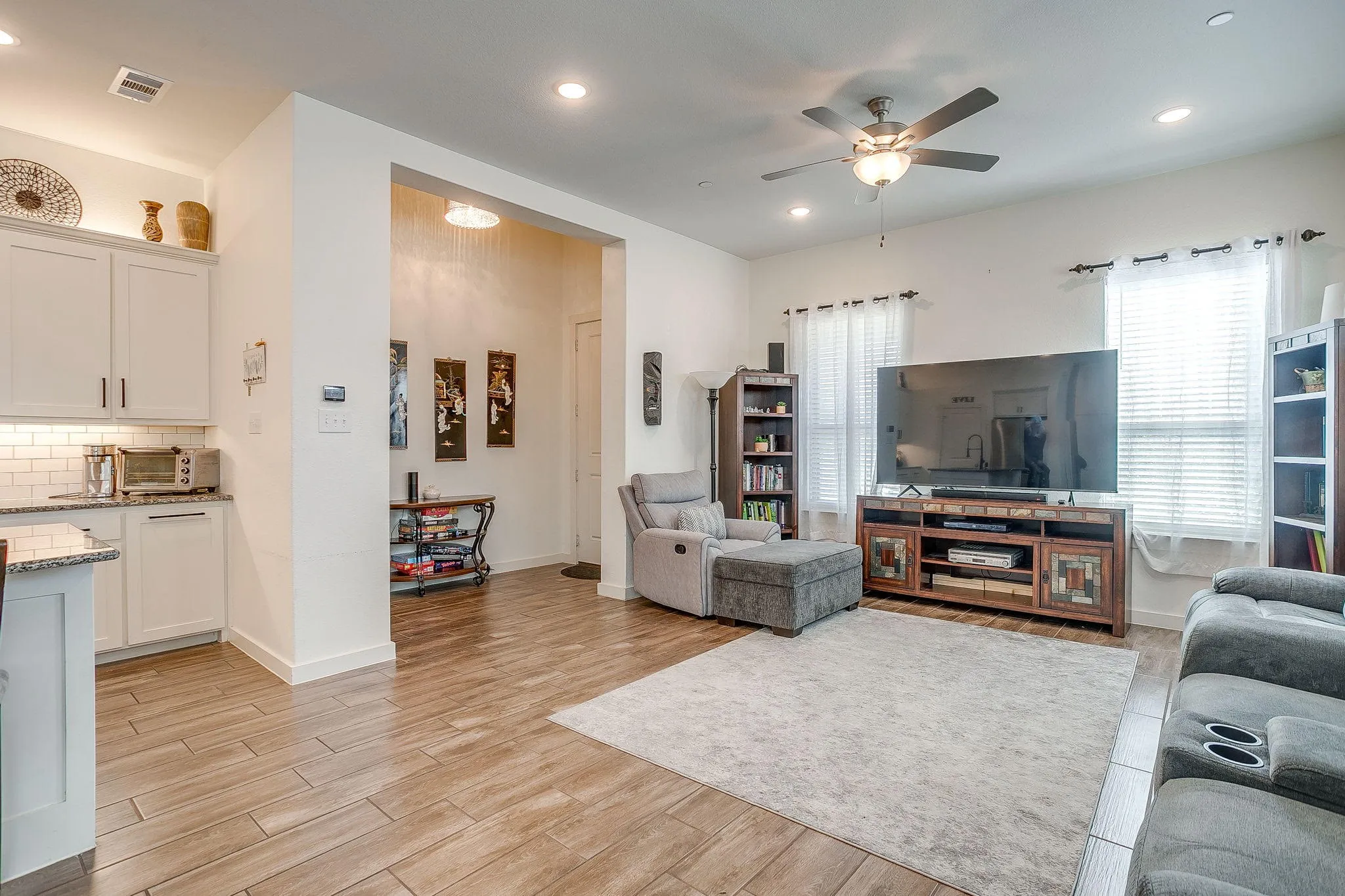 Wood-finish flooring throughout, recessed lighting, and a ceiling fan with integrated light