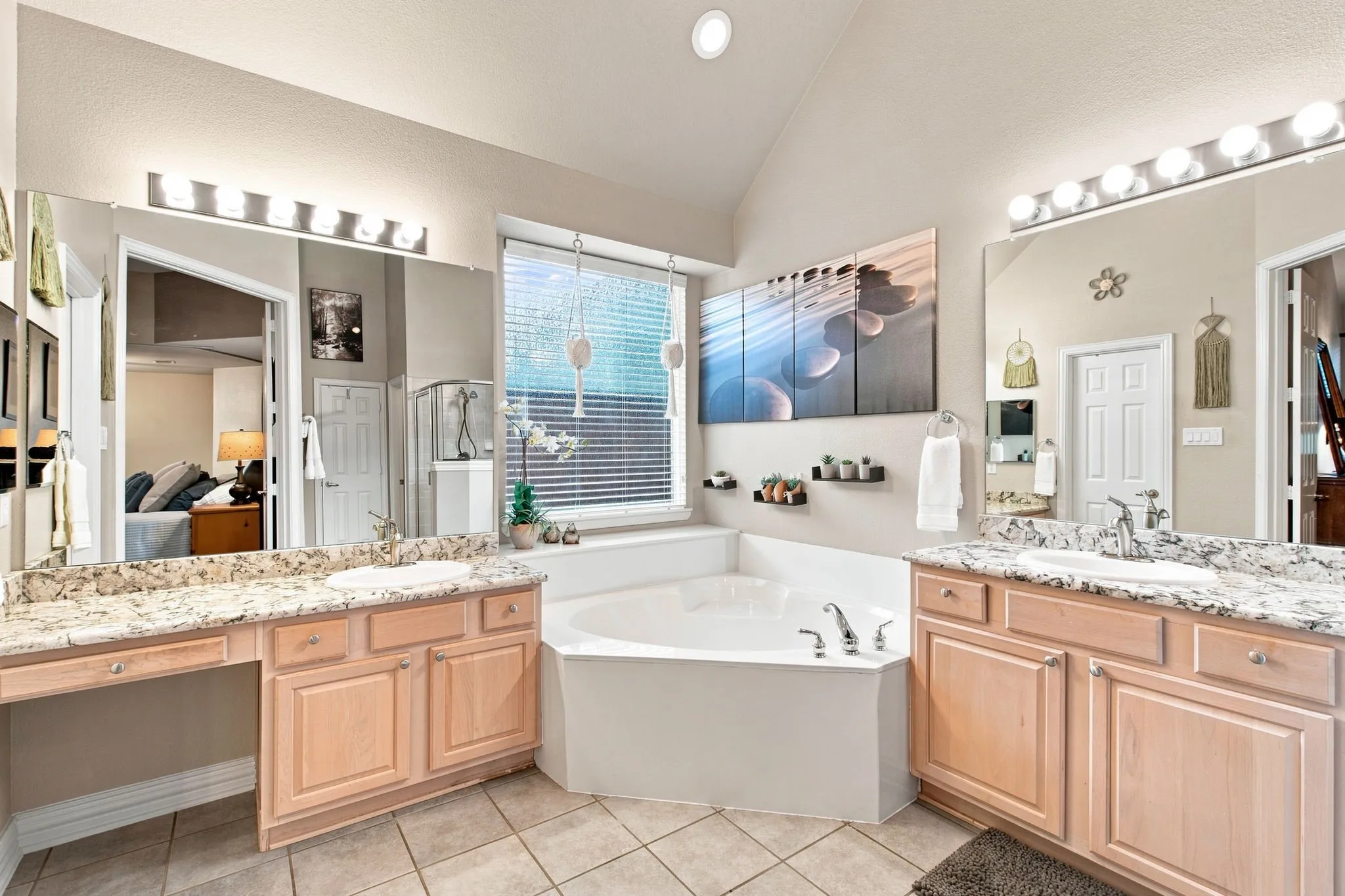 Dual vanity with stone-finish countertops, undermount sinks, and wood-finish cabinetry