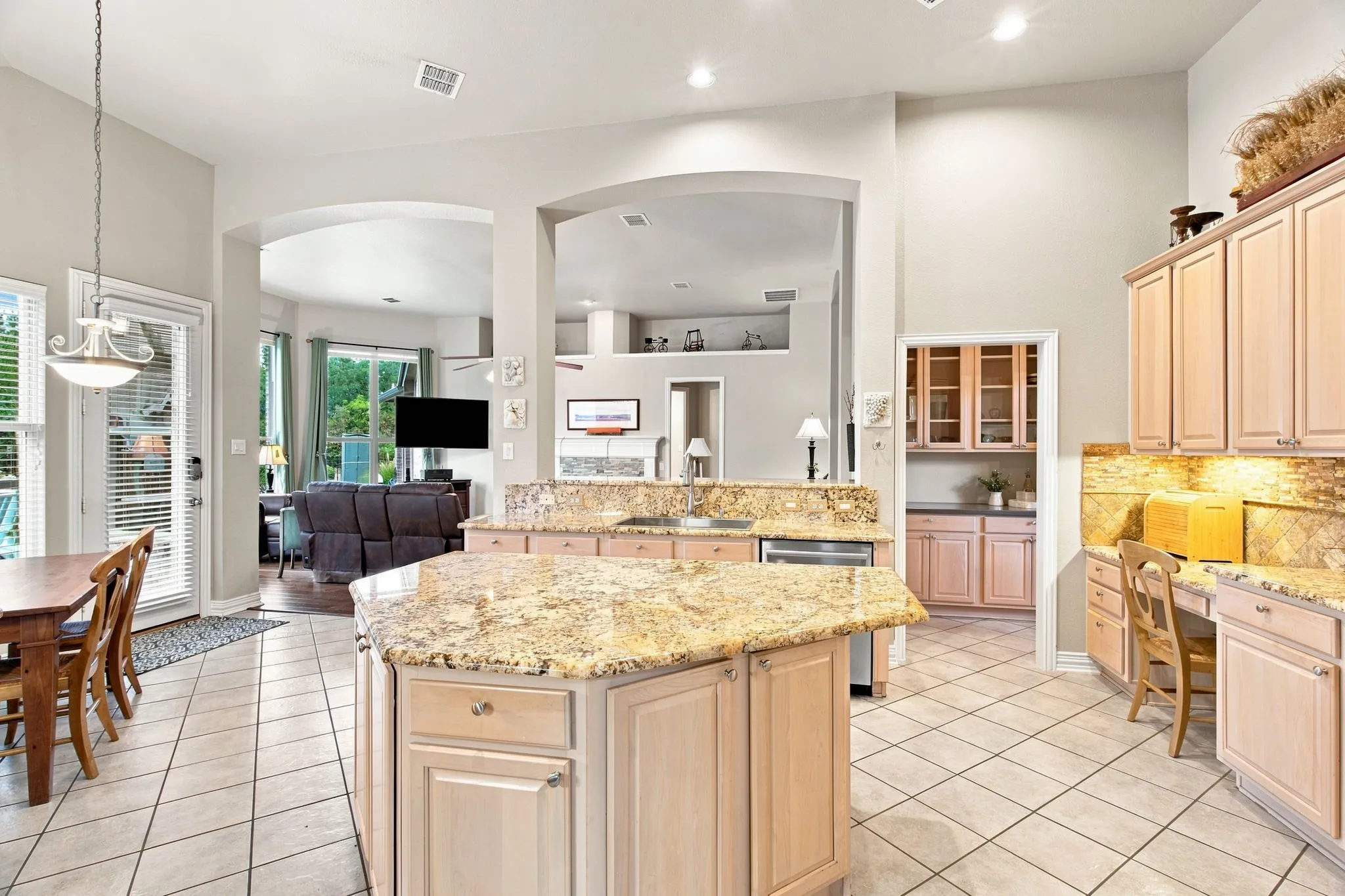 Kitchen featuring a large central island, granite countertops, tile flooring, recessed lighting, and light wood cabinetry