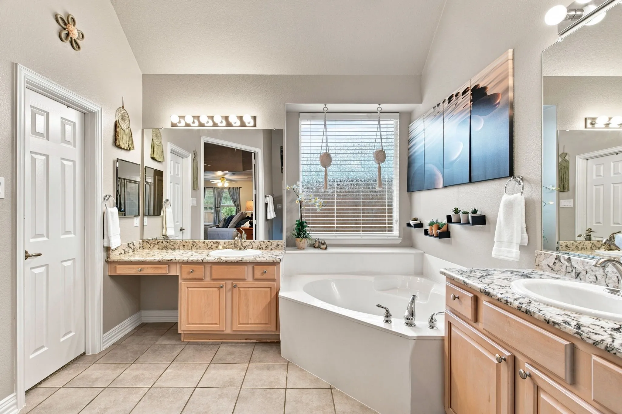 Double vanity with light wood cabinetry and granite countertops