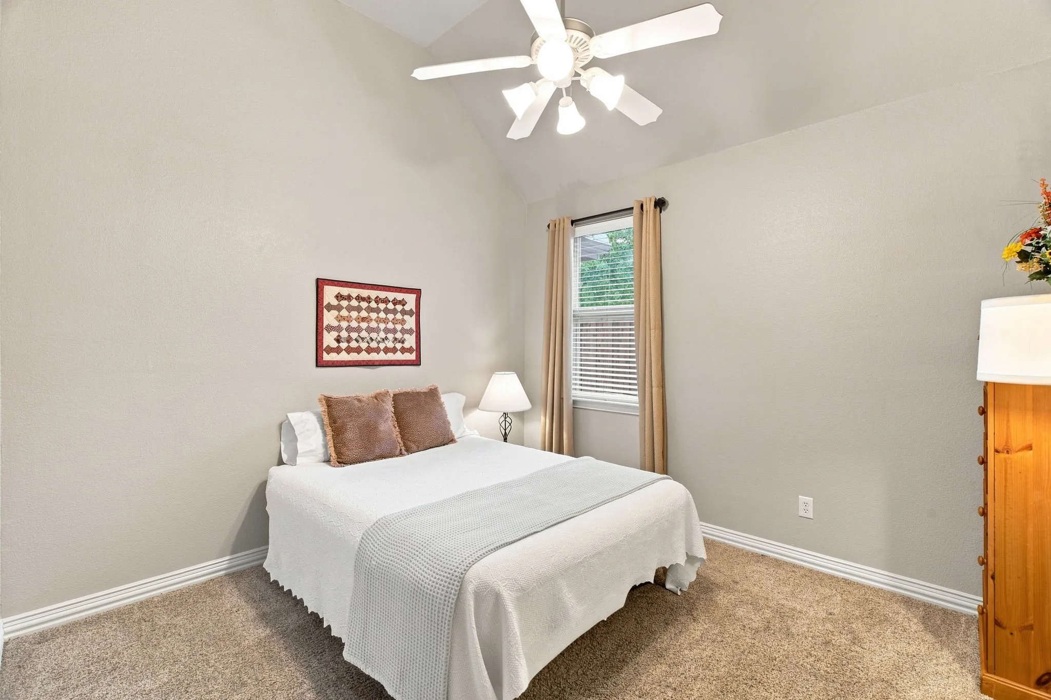 Vaulted ceiling with ceiling fan, carpet flooring, window with blinds, and neutral wall paint