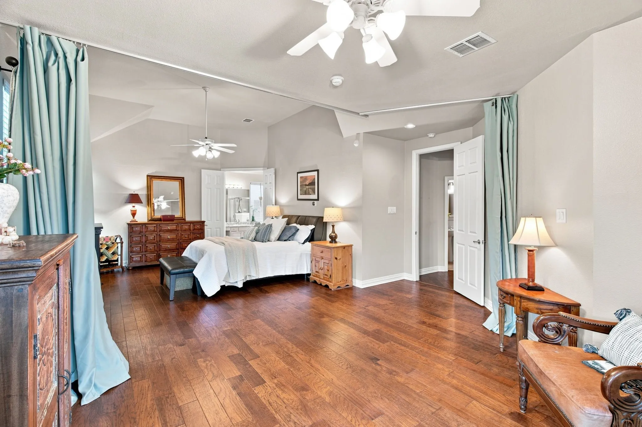 Hardwood flooring, vaulted ceiling, ceiling fan, and double doors