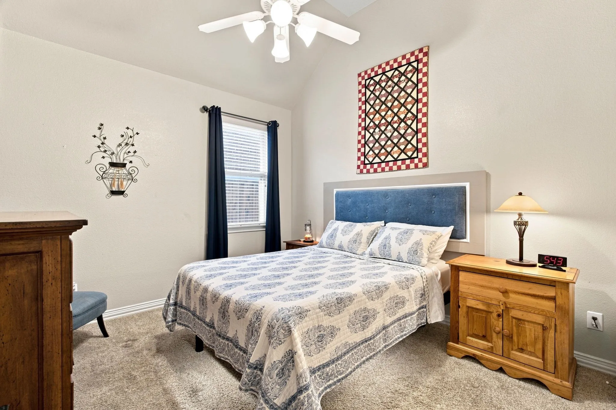 Carpeted bedroom featuring a vaulted ceiling, a ceiling fan with light fixture, and a window with blinds