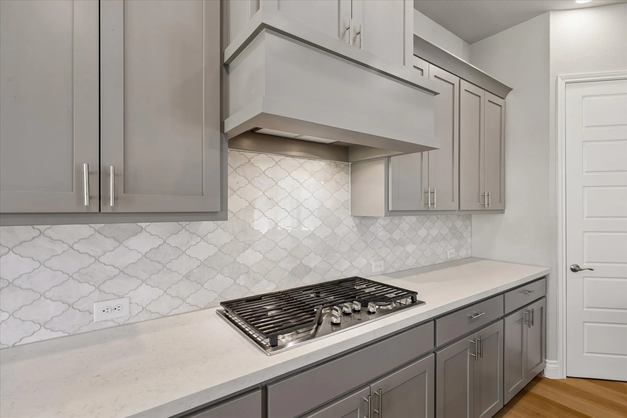 Five burner Gas cooktop, under cabinet lighting, beautiful back splash, vent hood vents out of kitchen