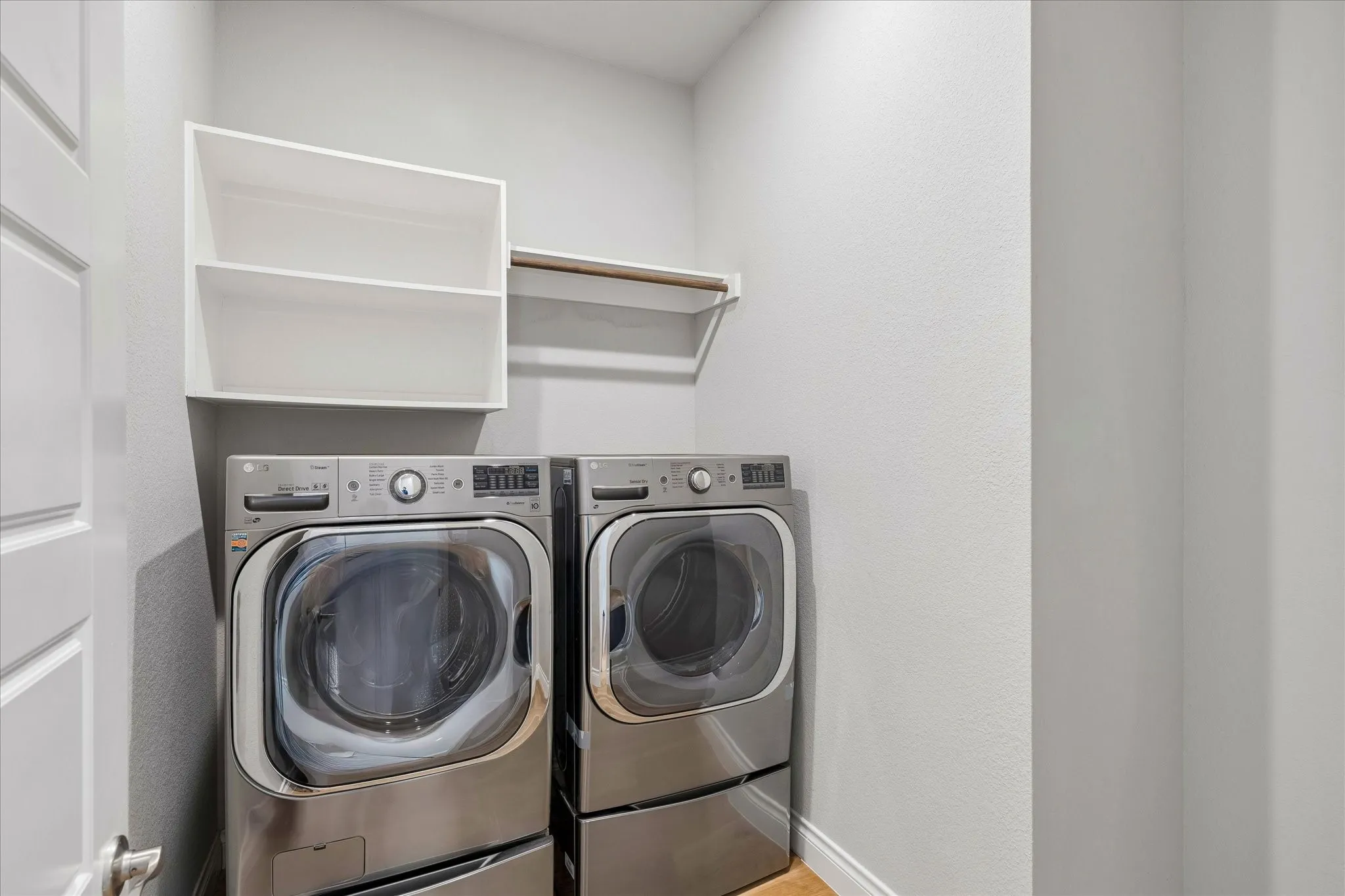 Utility room with built-in shelves and clothes rod and room for freezer or extra refrigerator
