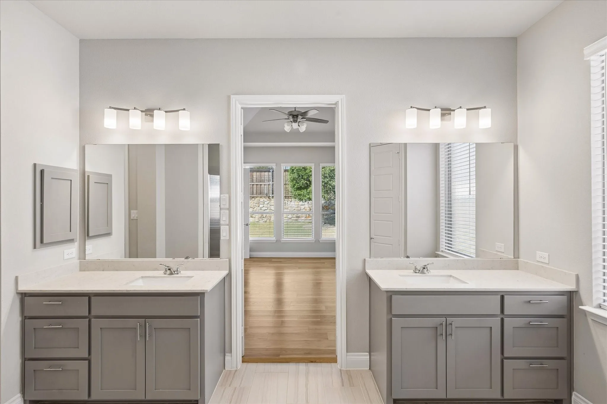 Primary bathroom with double vanities and a medicine cabinet
