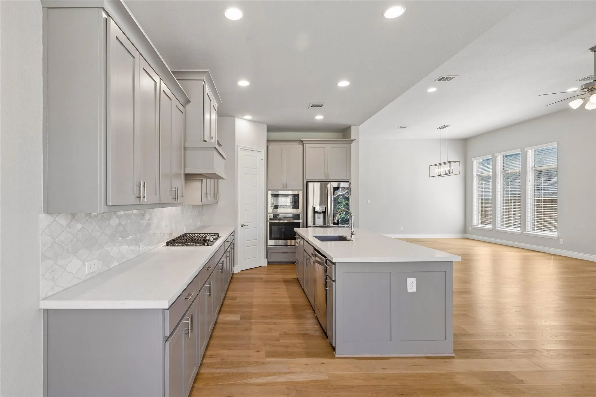 Open concept floor plan with kitchen with island and walk-in pantry, view of living and dining rooms