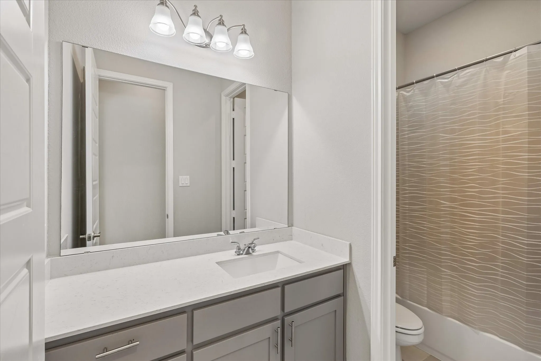 Full bathroom between two bedrooms at front of the home, toilet and tub/shower combo in a separate