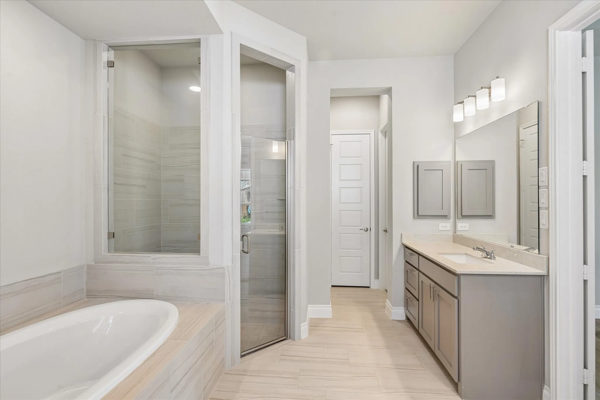 Primary bathroom with garden tub, walk-in shower, linen closets, and two walk-in closets
